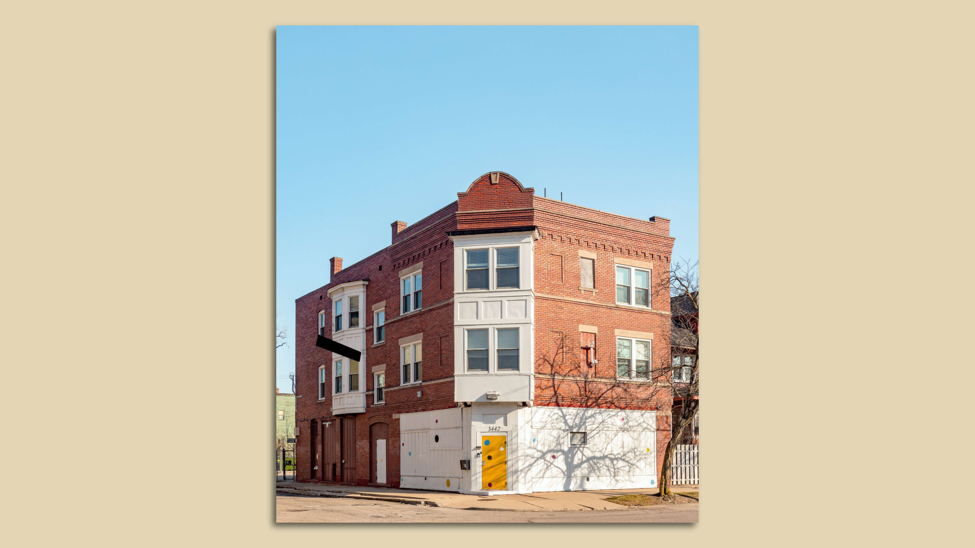 A corner brick building with a cute yellow door.