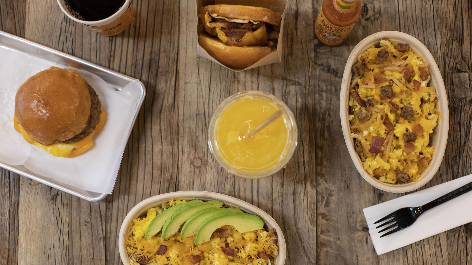 Breakfast bowls and sandwiches shown from above with cheese, meat and avocado.