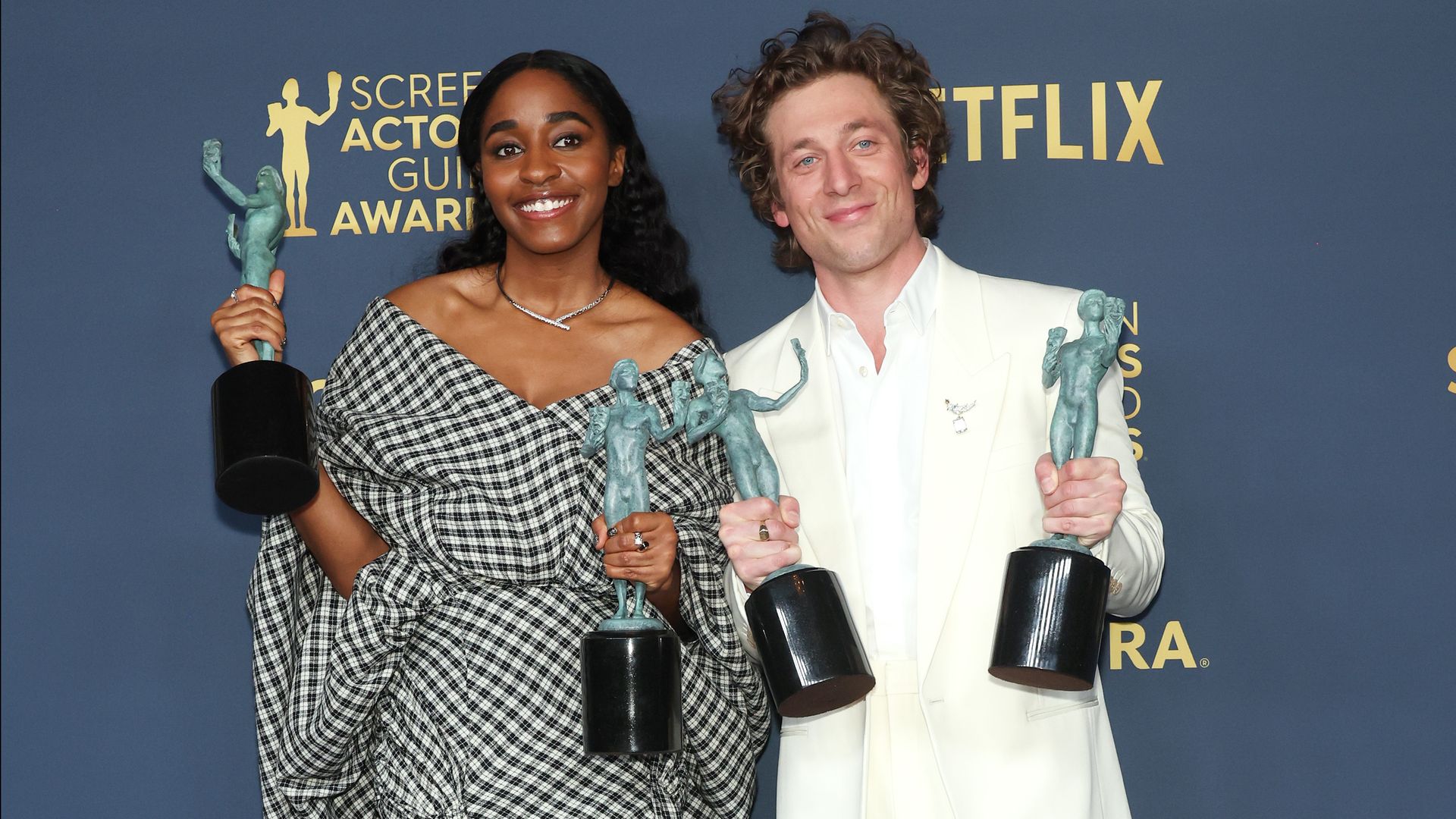 Photo of two people holding awards 