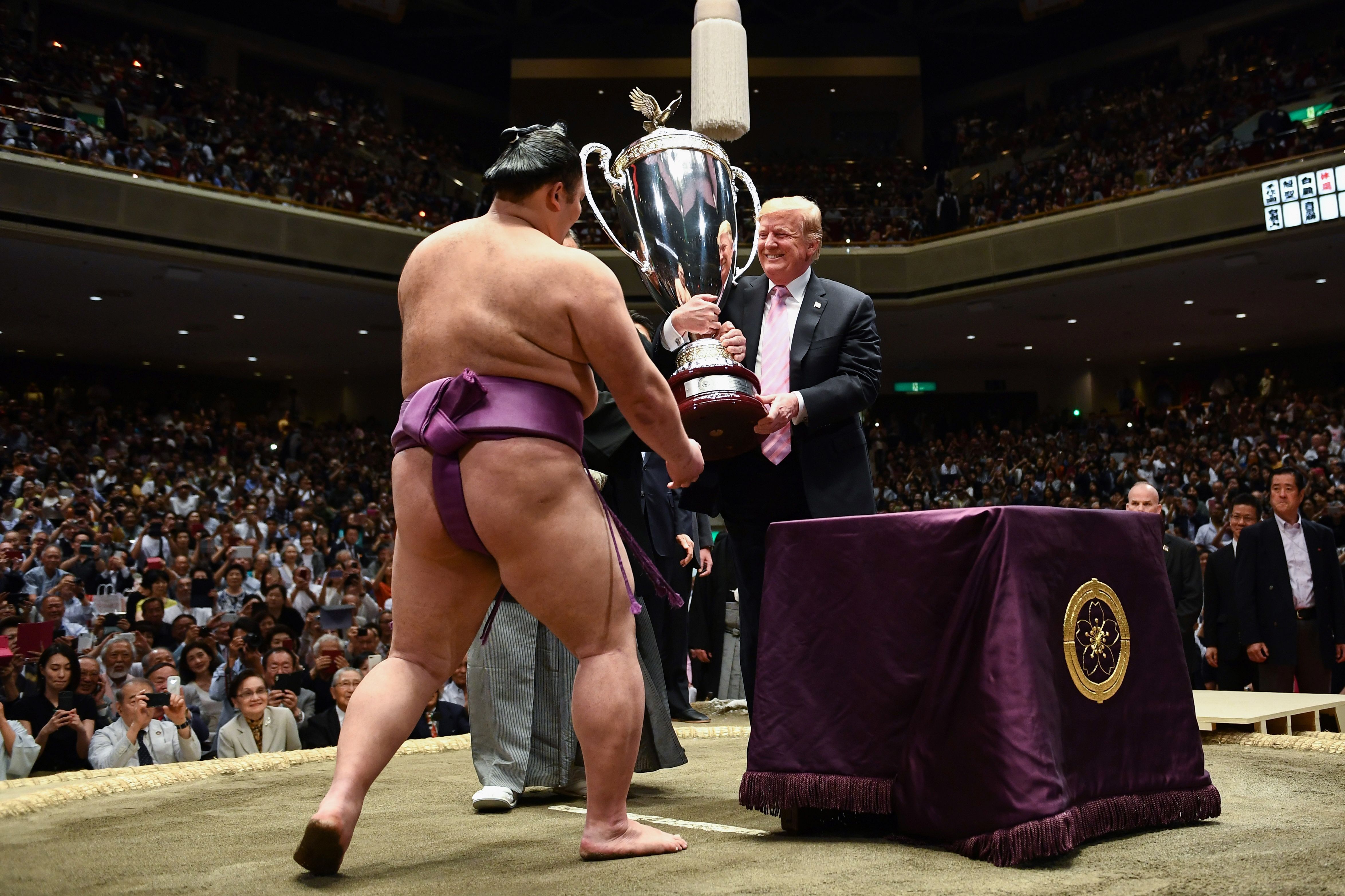 US President Donald Trump presents the President's Cup to sumo wrestler Asanoyama during the Summer Grand Sumo Tournament at Ryogoku Kokugikan Stadium in Tokyo on May 26, 2019.