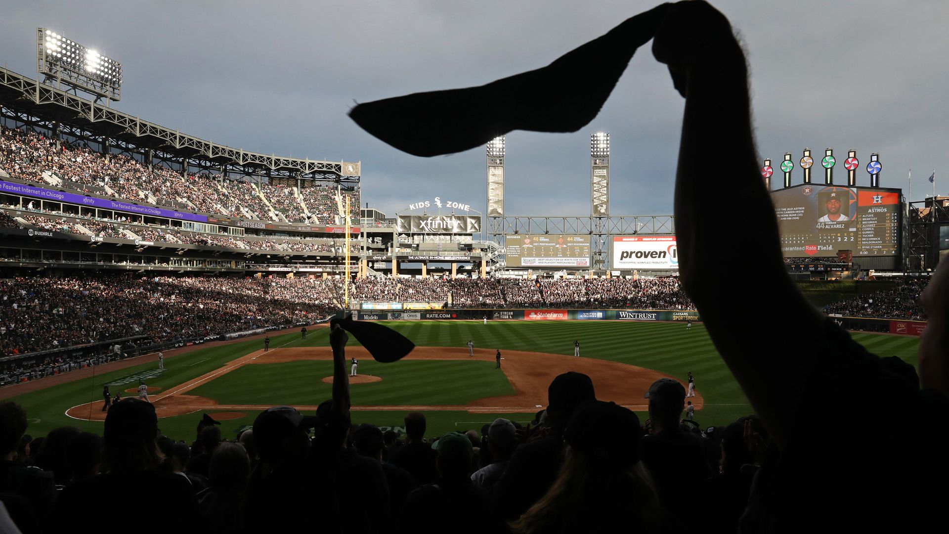 Photo of a hang waiving a towel at a baseball game. 