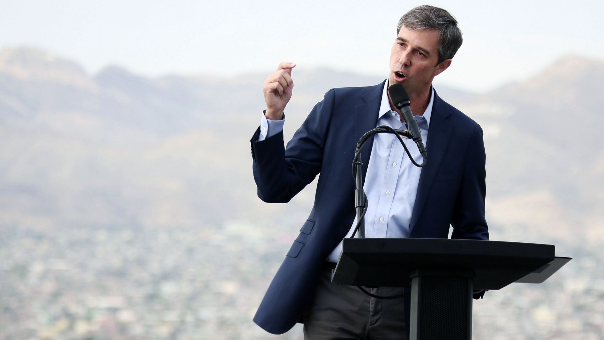 In this image, Beto stands at a podium outside and speaks to a crowd.