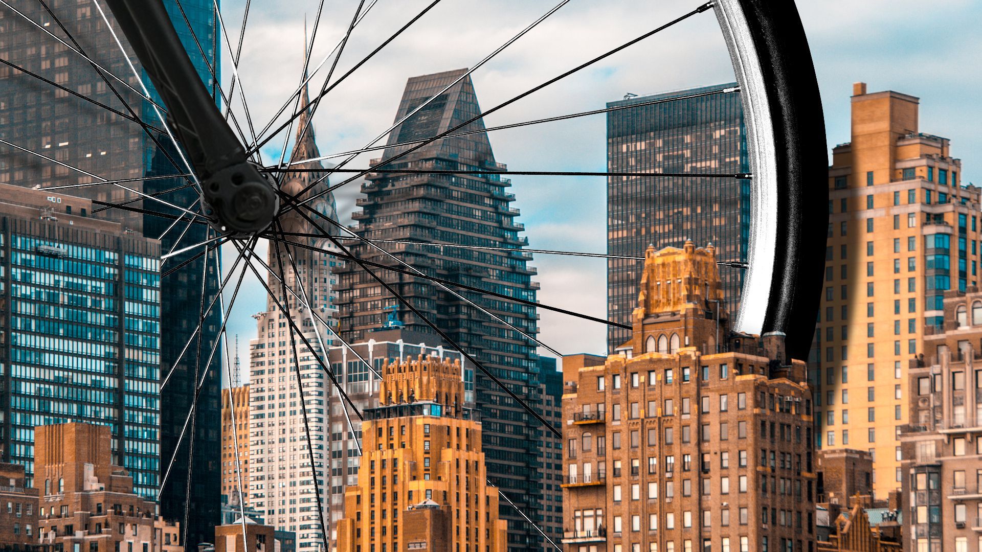 Illustration of a giant bicycle wheel in between small skyscrapers