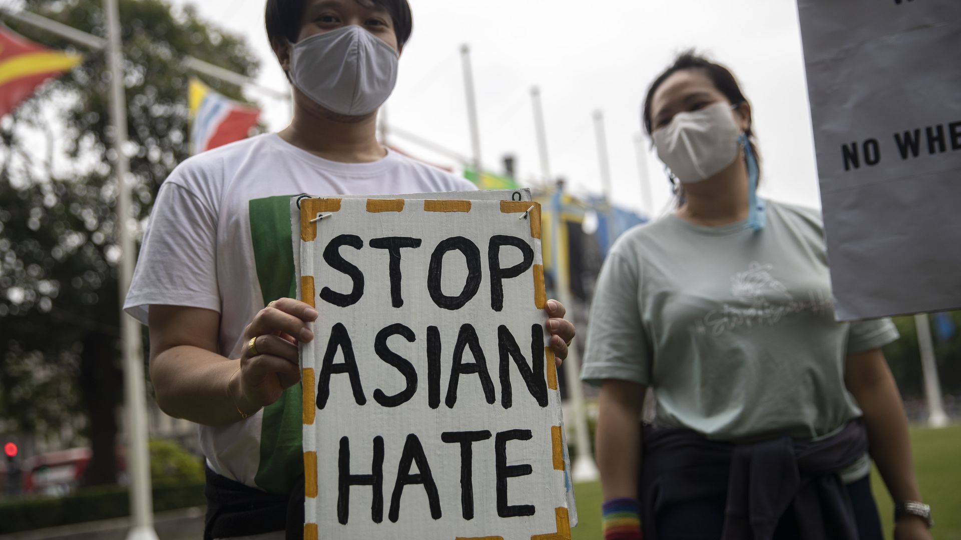 Protesters hold placards outside Parliament Square during the Stop Asian Hate rally in London