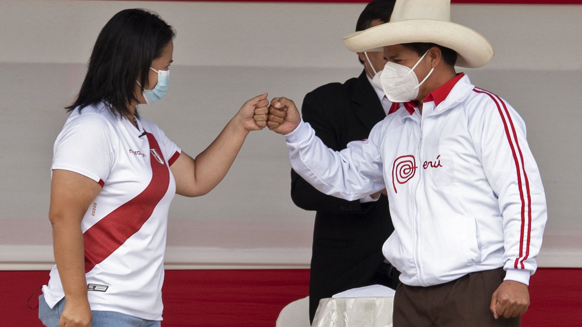 Peru's presidential candidates Keiko Fujimoi and Pedro Castillo bump fists.