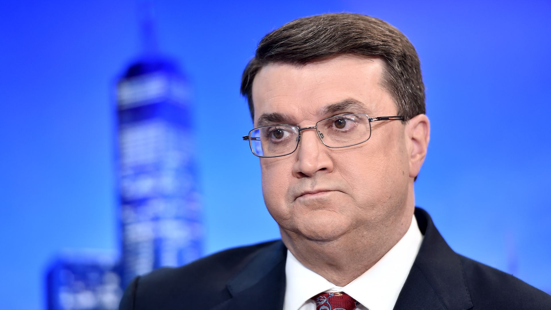 In this image, Robert Wilkie sits in a suit and tie.