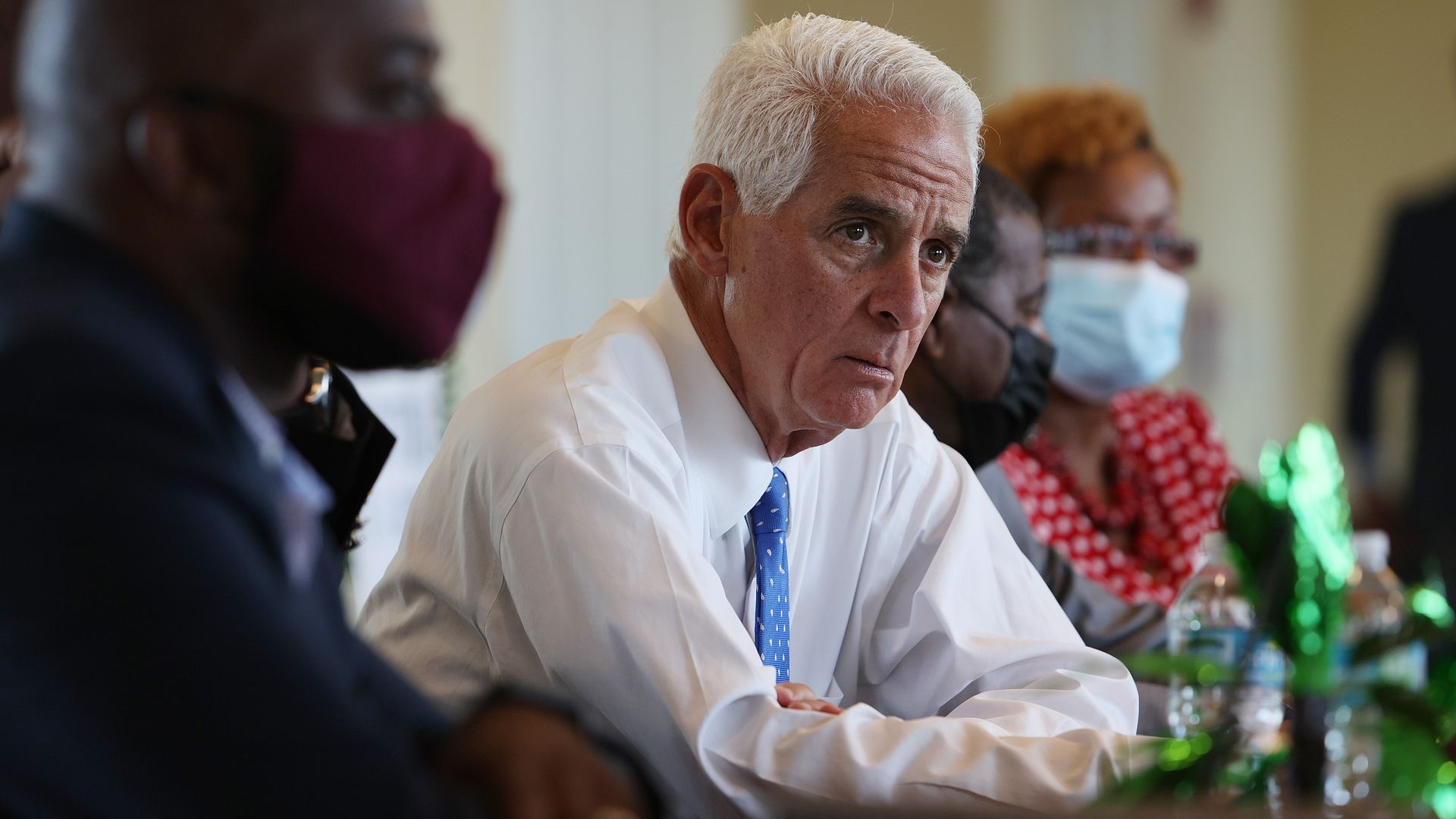 Charlie Crist leans forward at a meeting