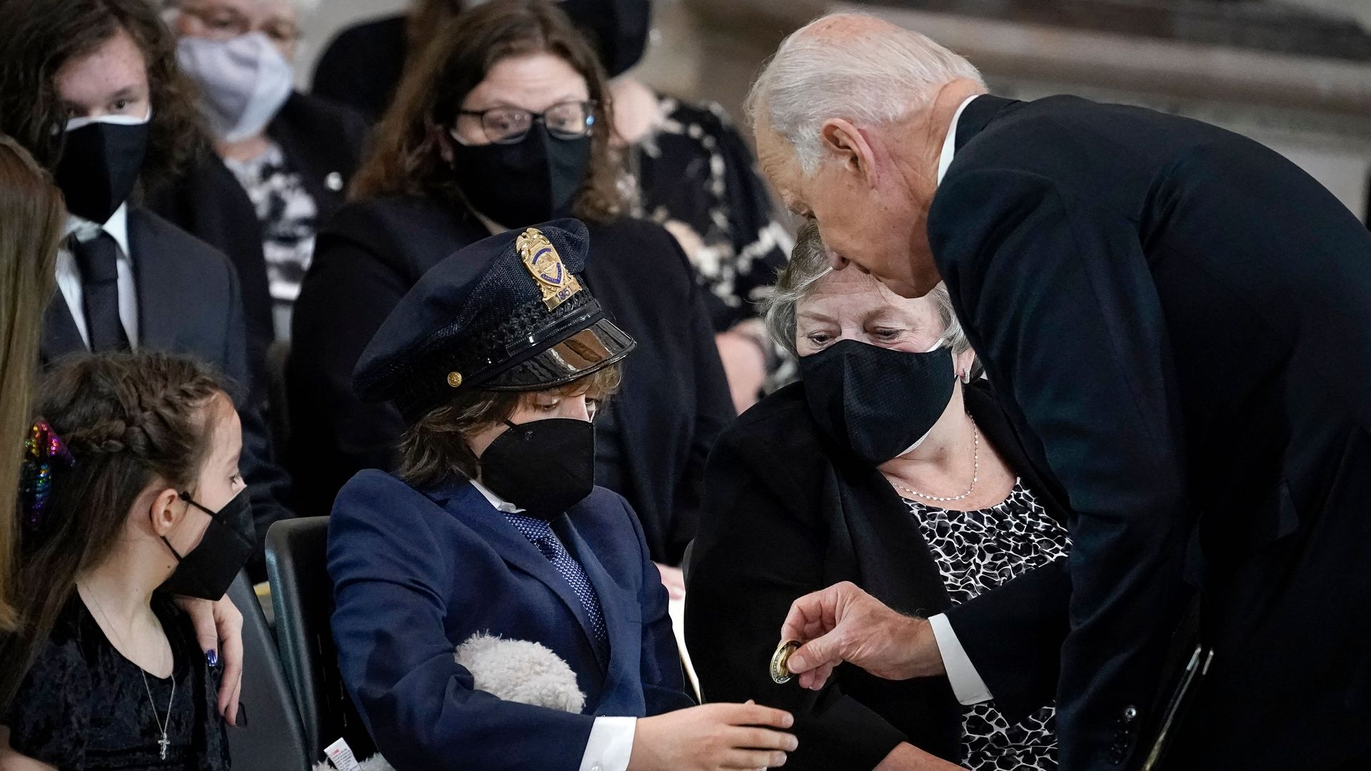 President Biden is seen presenting one of his Challenge Coins to the son of slain Capitol Police Officer Billy Evans.