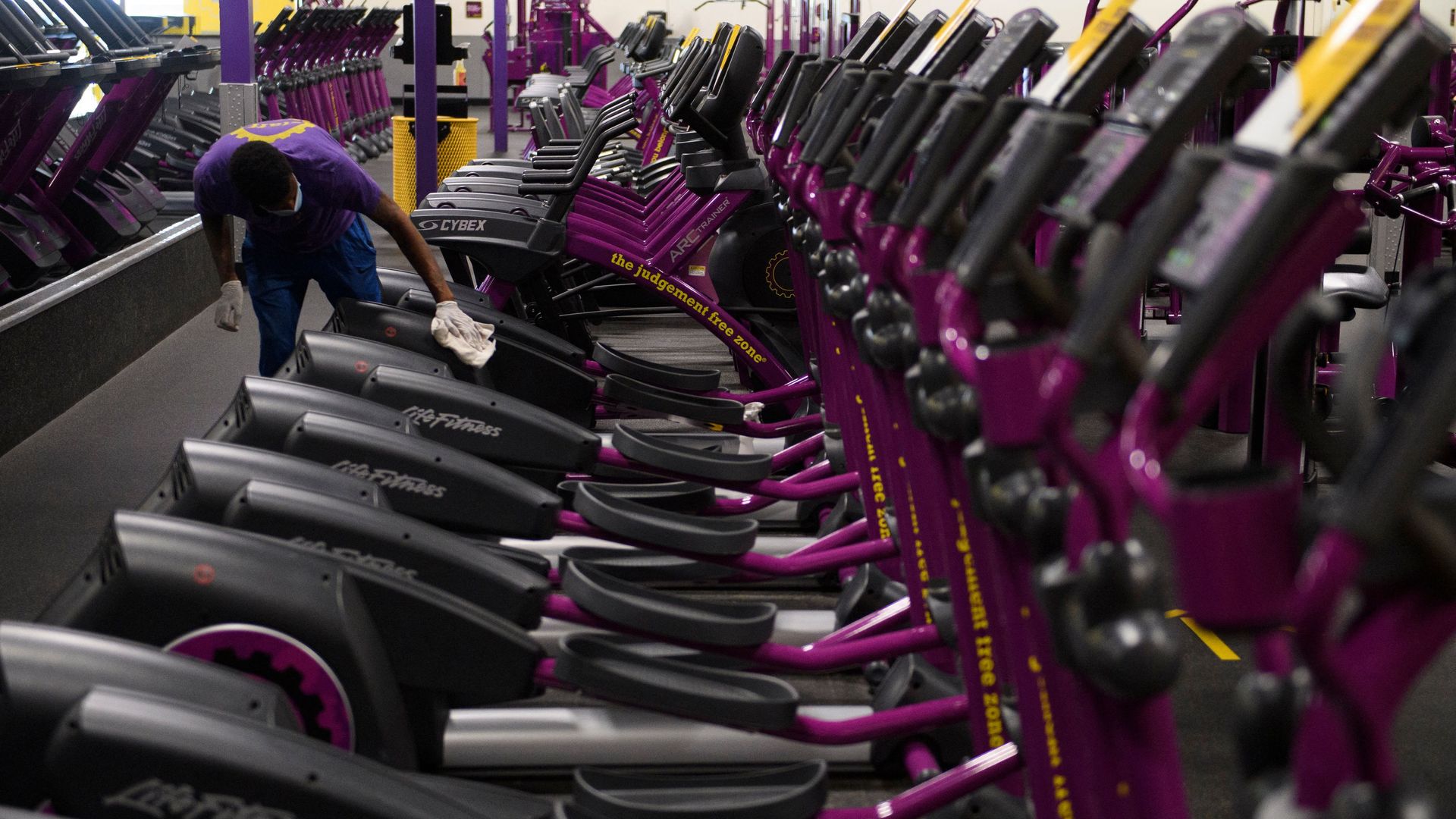 An employee at Planet Fitness gym cleans the equipment.