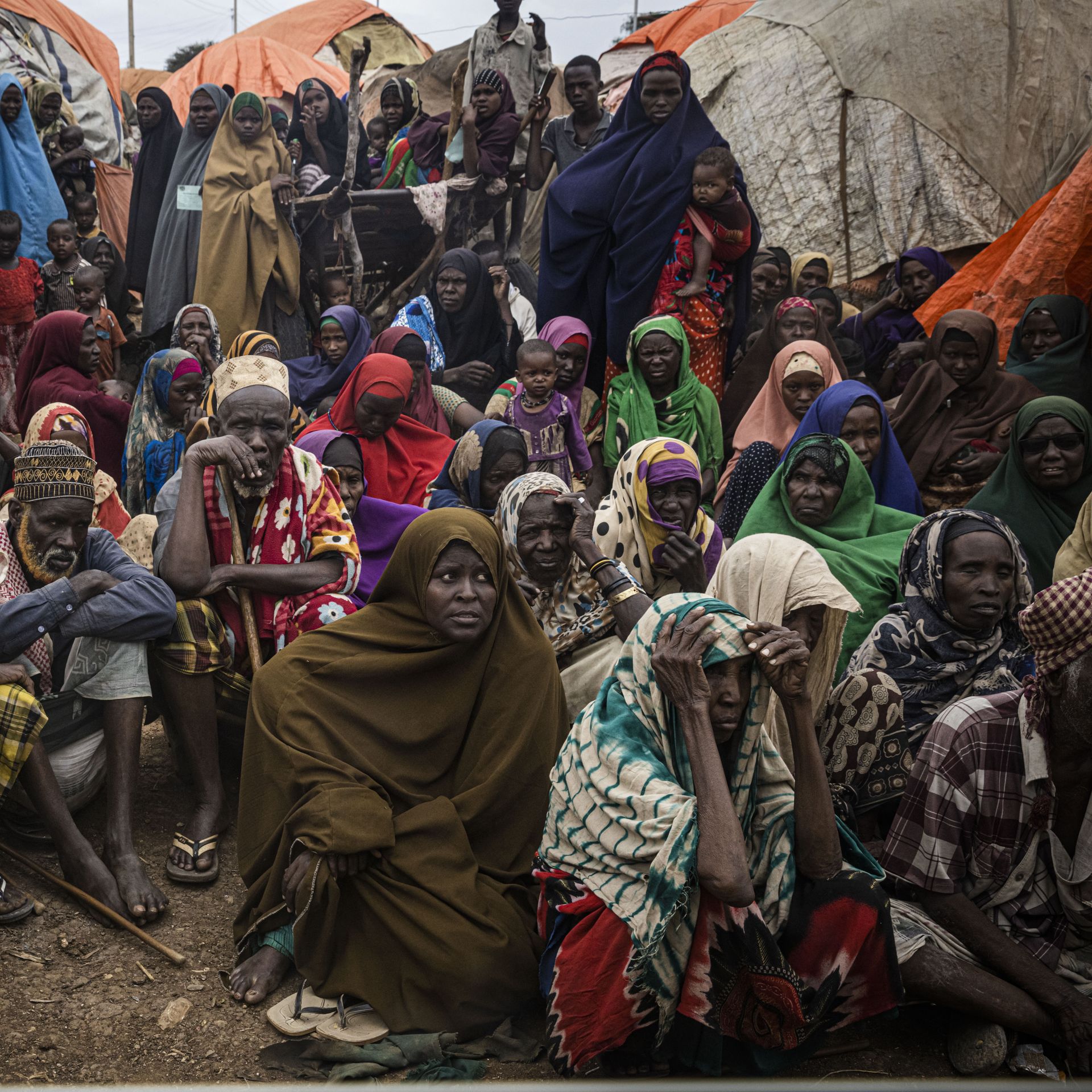 People sit next to tents in a displacement camp for people impacted by drought on September 3, 2022 in Baidoa, Somalia
