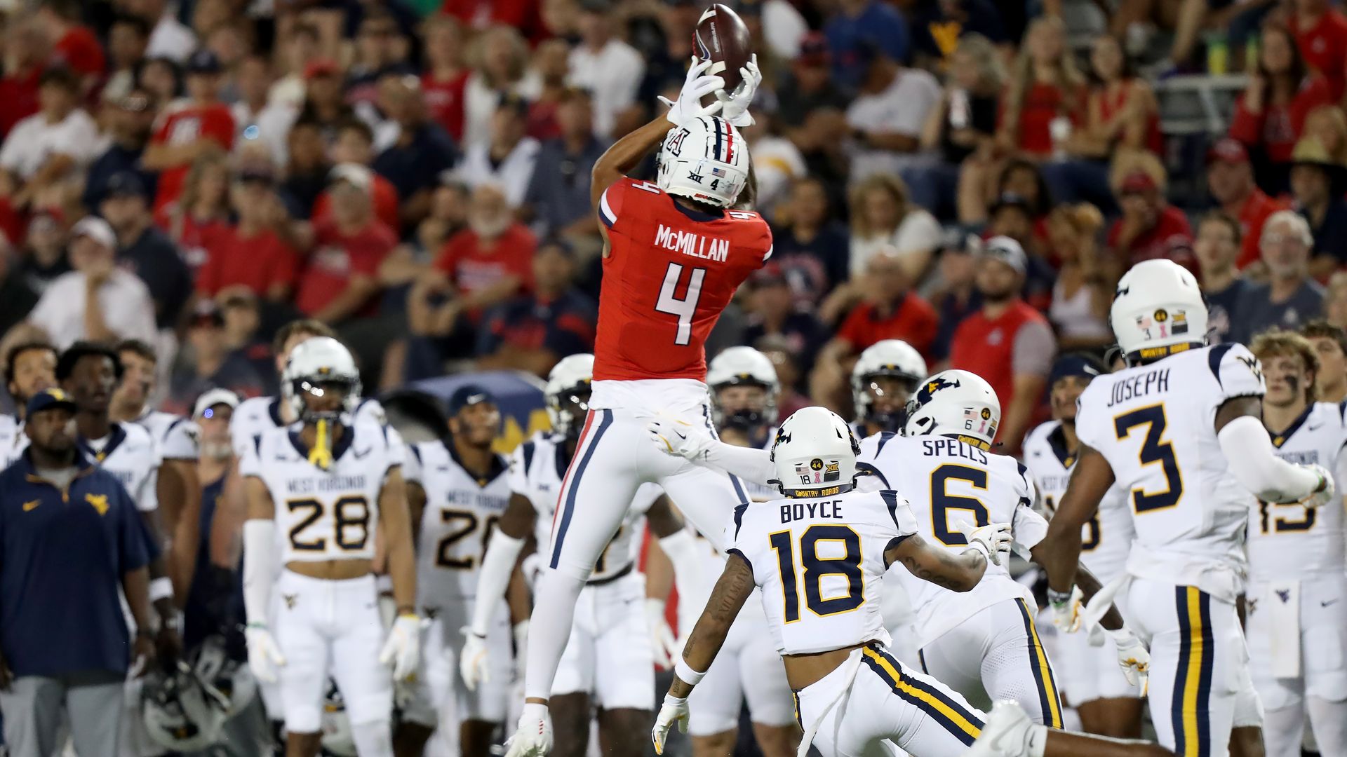 Arizona Wildcats wide receiver Tetairoa McMillan #4 jumps high to make a catch during a football game between the West Virginia Mountaineers and the Wildcats.