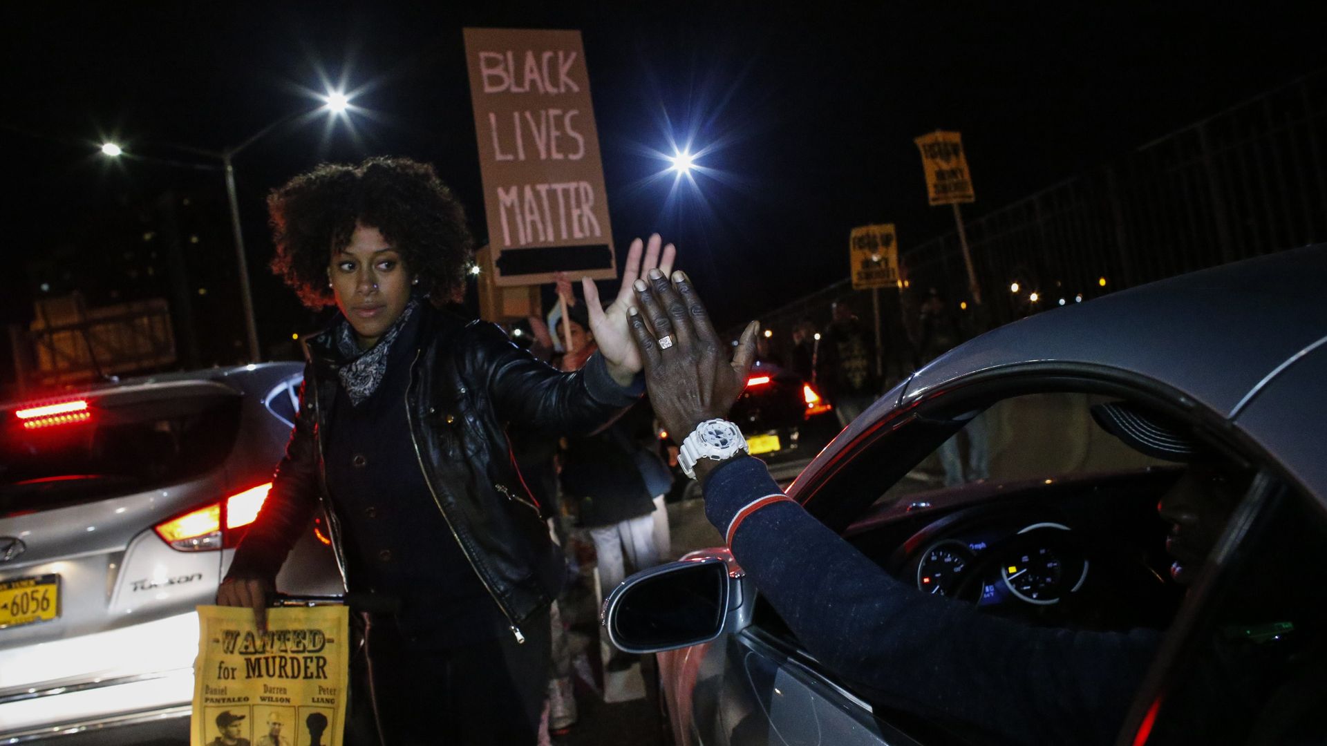 A driver shakes hands with a demonstrator during a protest march in New York City after a grand jury declined to prosecute a white police officer for the killing Michael Brown.