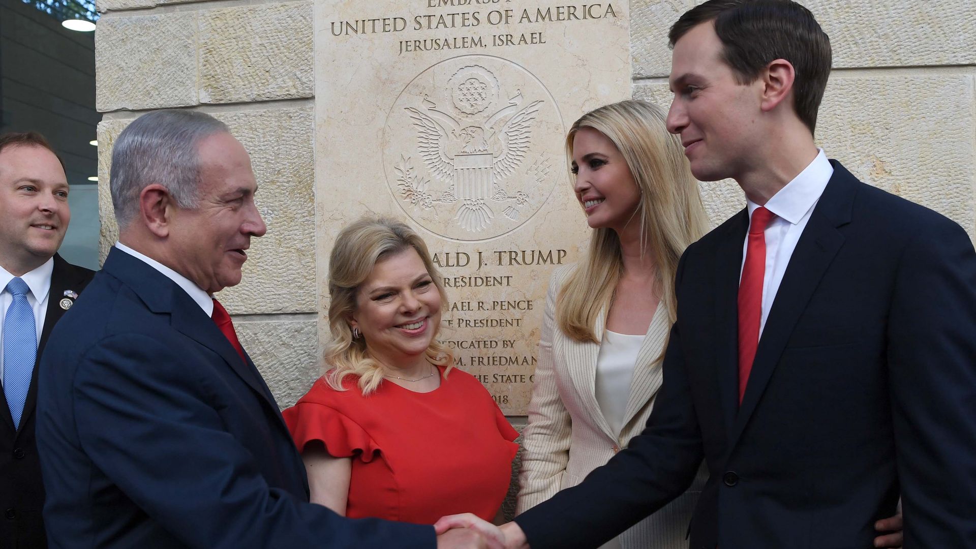 Jared Kushner and Benjamin Netanyahu shake hands, as their wives stand next to them. 