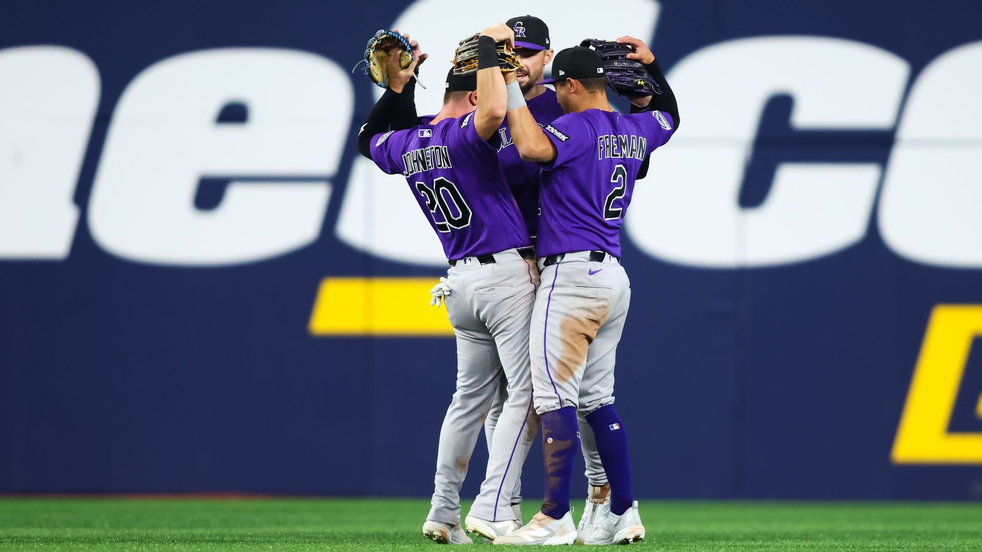 Several baseball players celebrate by flexing their arms near one another. 