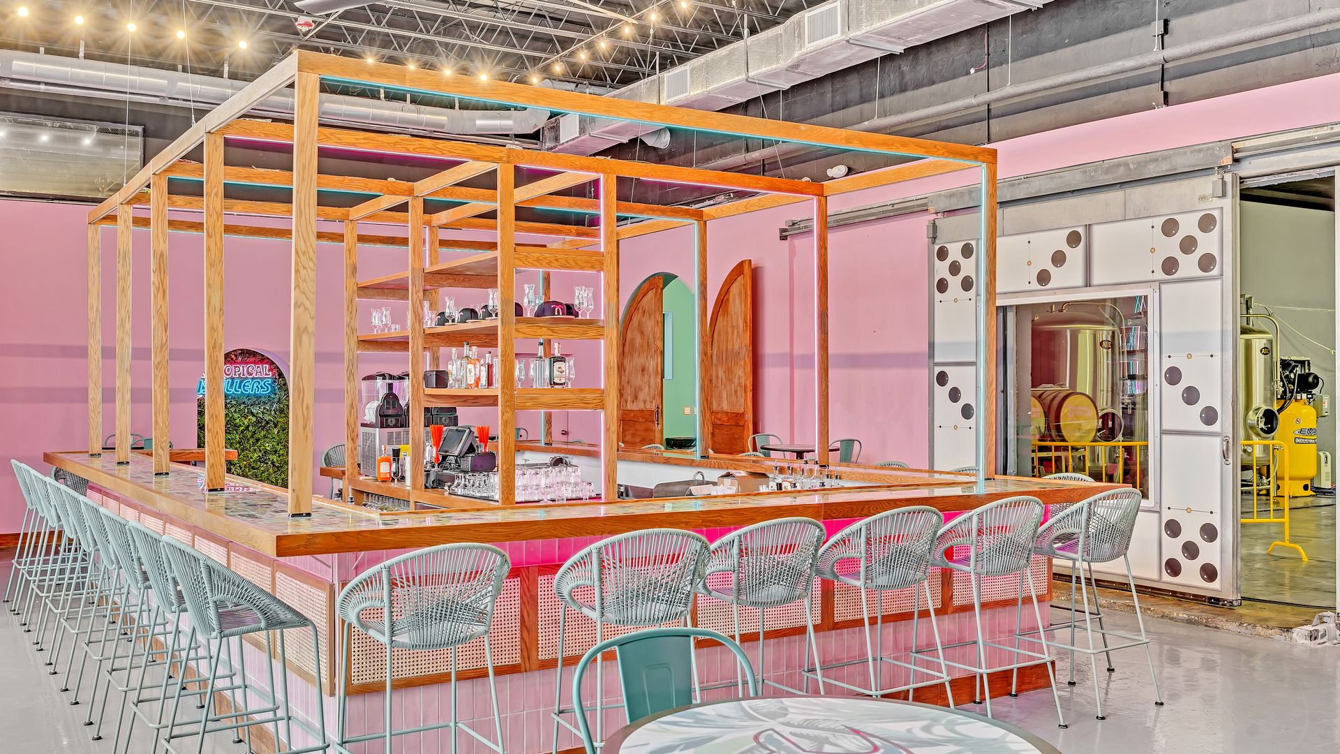 A pink room has a bar at the center 