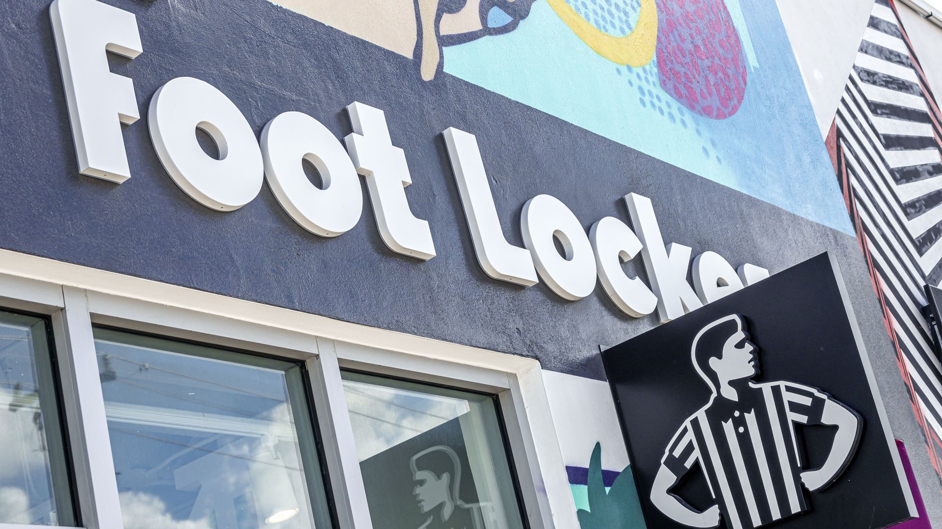 Foot Locker, spelled out in white lettering on a black backdrop, appears above a windowed entrance to one of the retailer's locations.