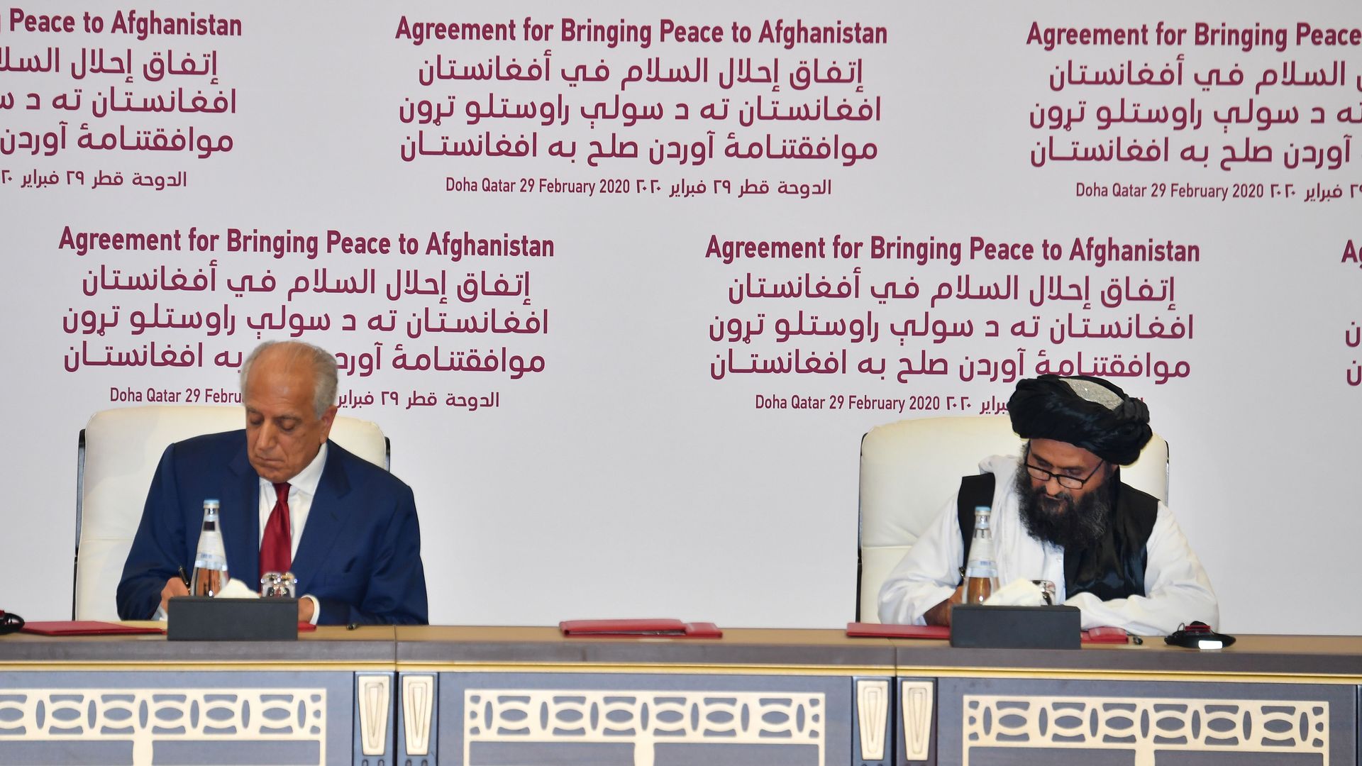 US Special Representative for Afghanistan Reconciliation Zalmay Khalilzad and Taliban co-founder Mullah Abdul Ghani Baradar sign a peace agreement during a ceremony