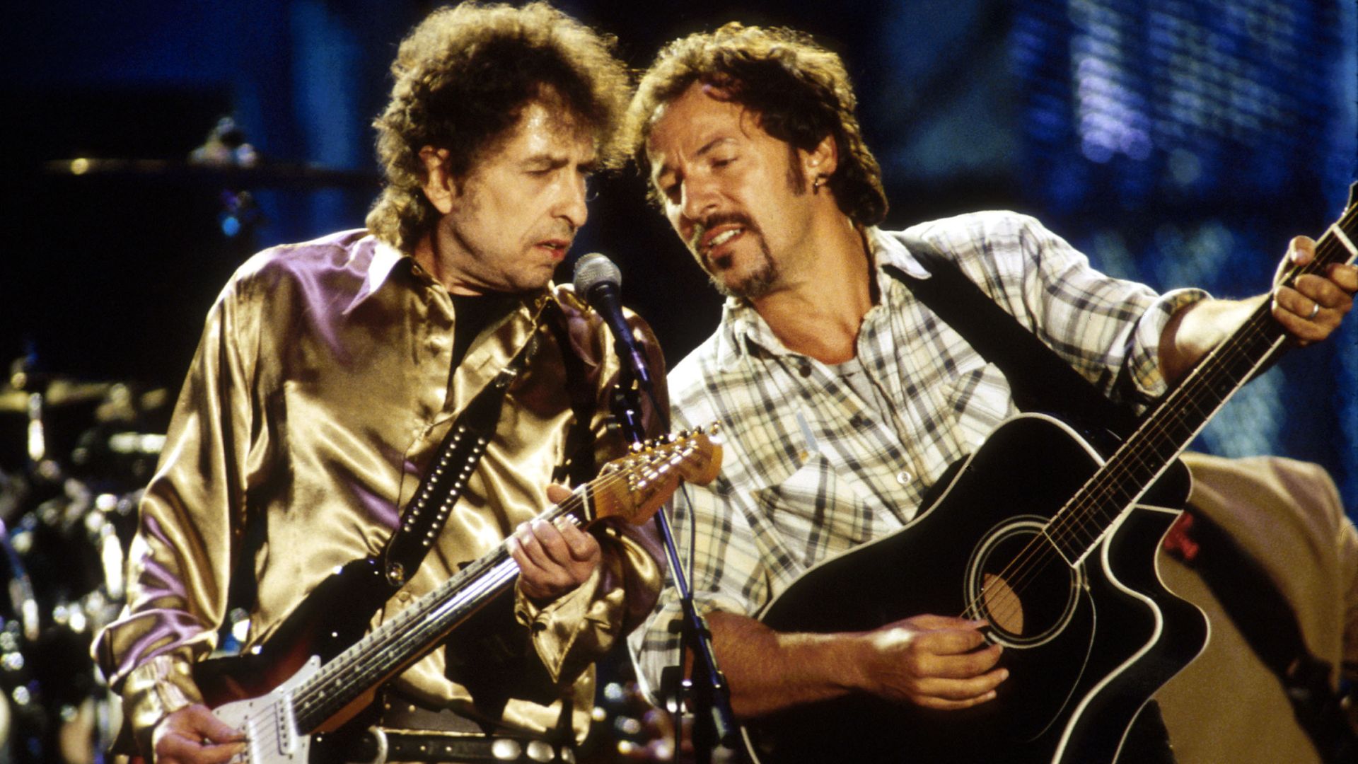Bob Dylan and Bruce Springsteen perform on stage together.