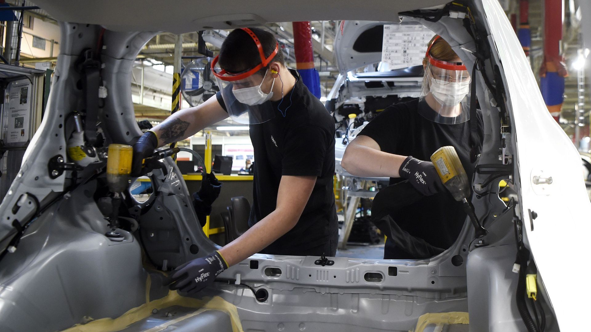 Mechanics working on assembling cars.