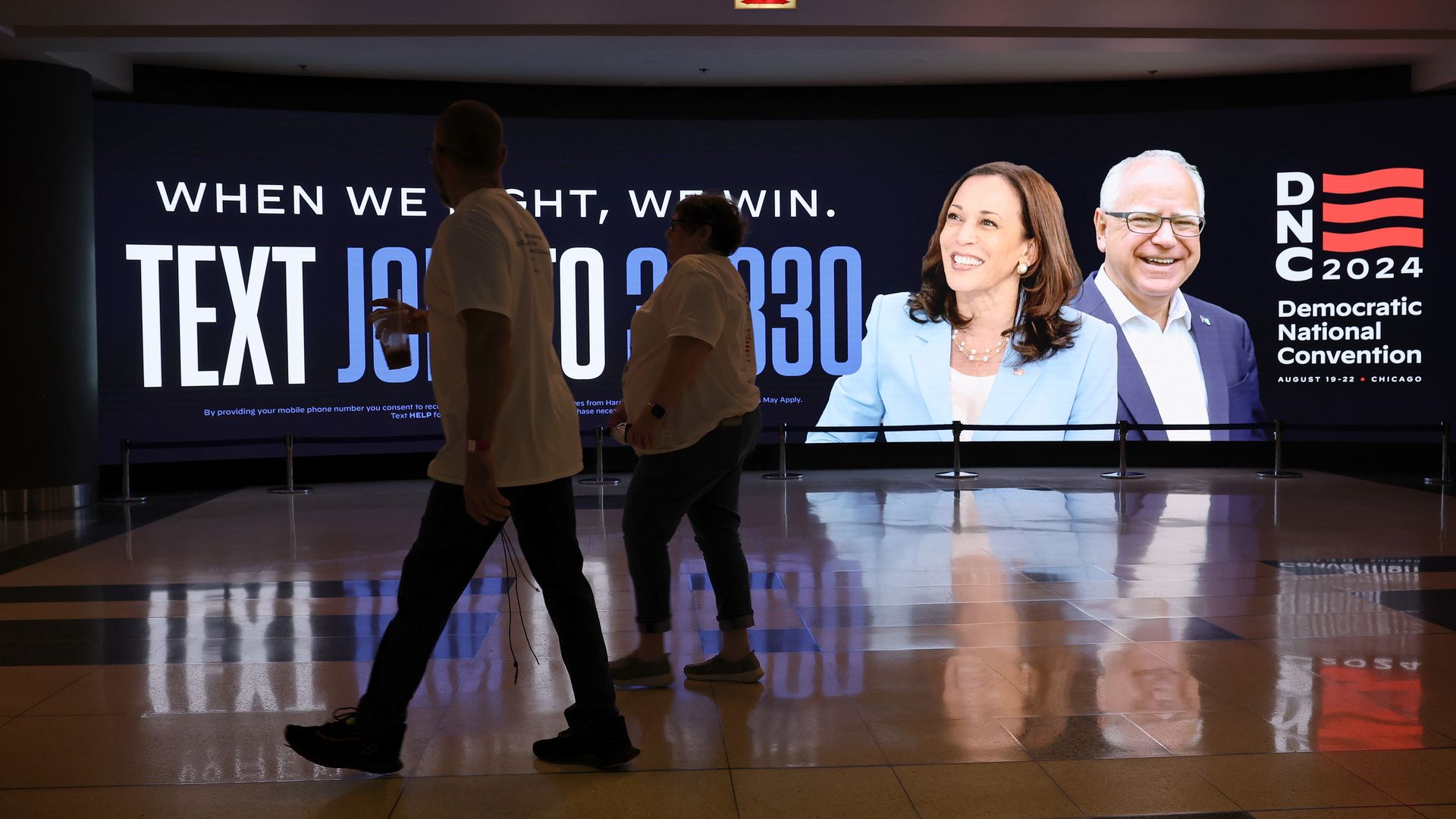 People walk by a sign for the Democratic National Convention (DNC) at the United Center on August 16, 2024 in Chicago, Illinois.