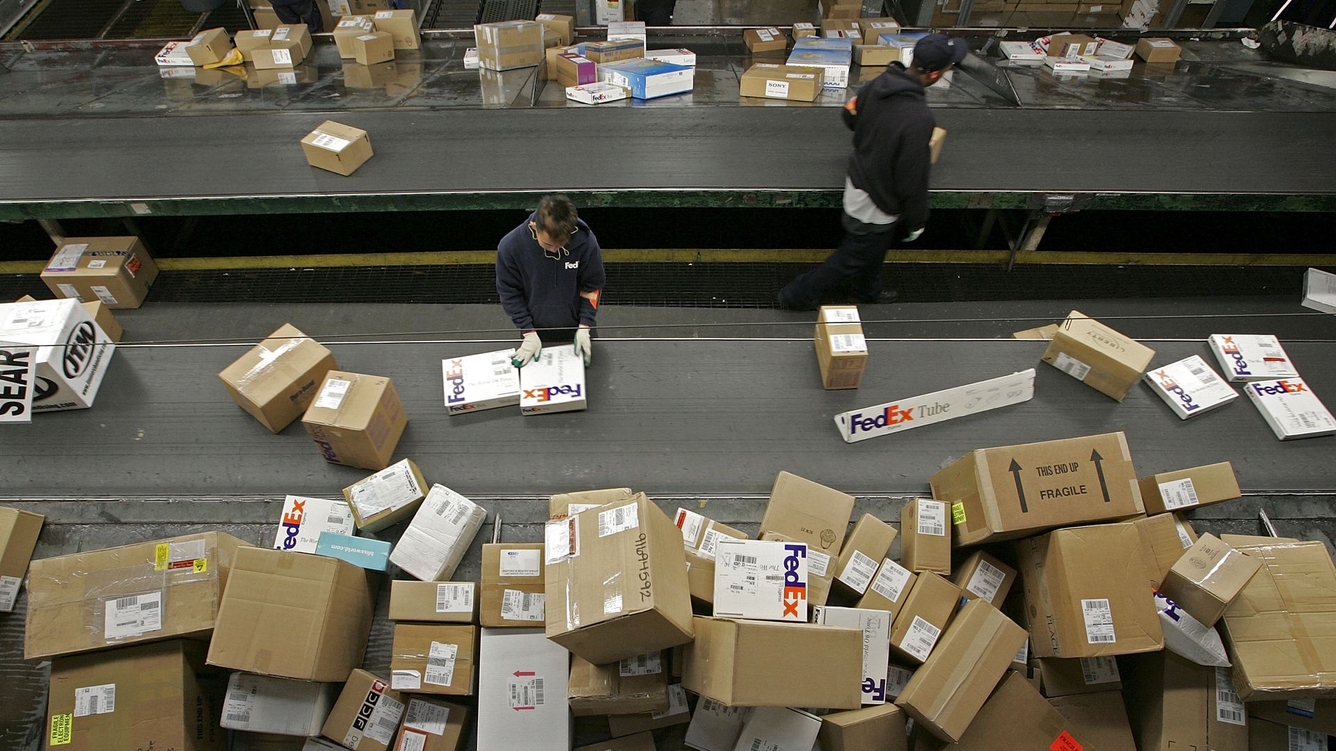 Workers in a warehouse surrounded by boxes 