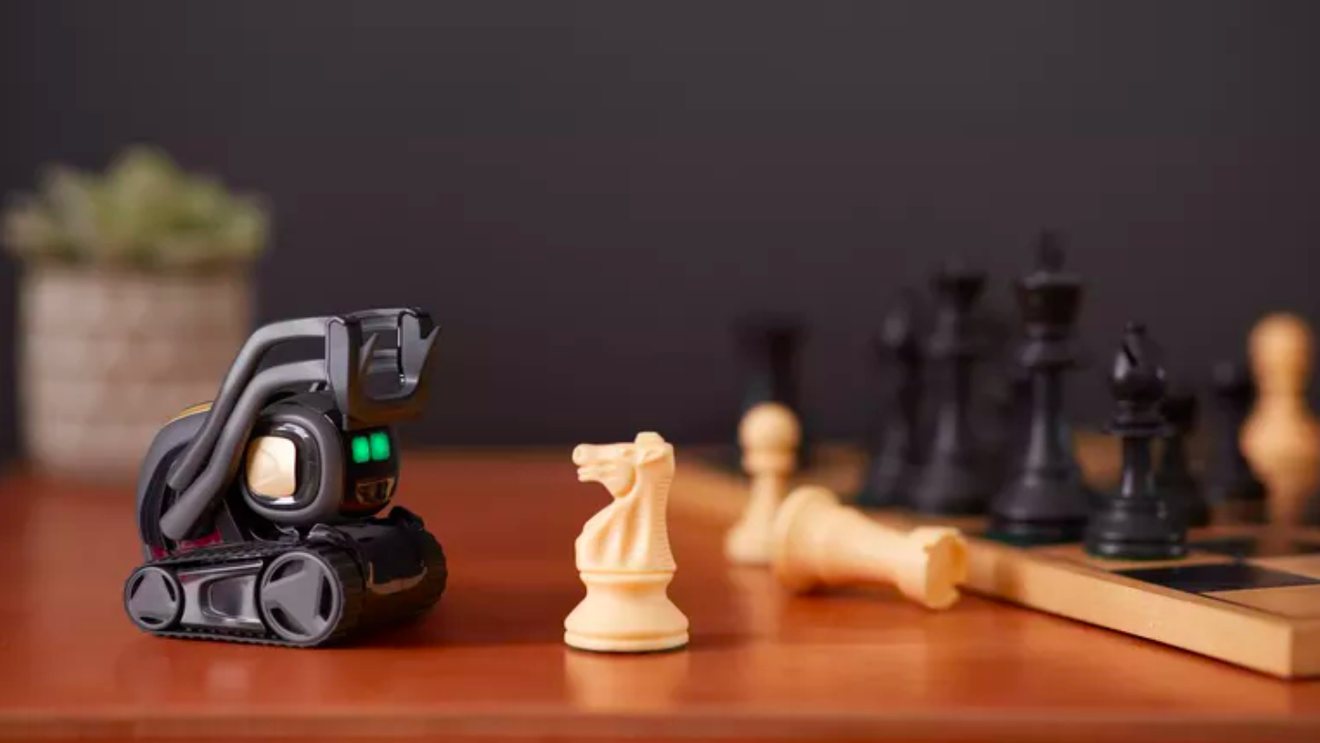 In this image, an Anki robot faces a chess board and a rook stands in front of it.
