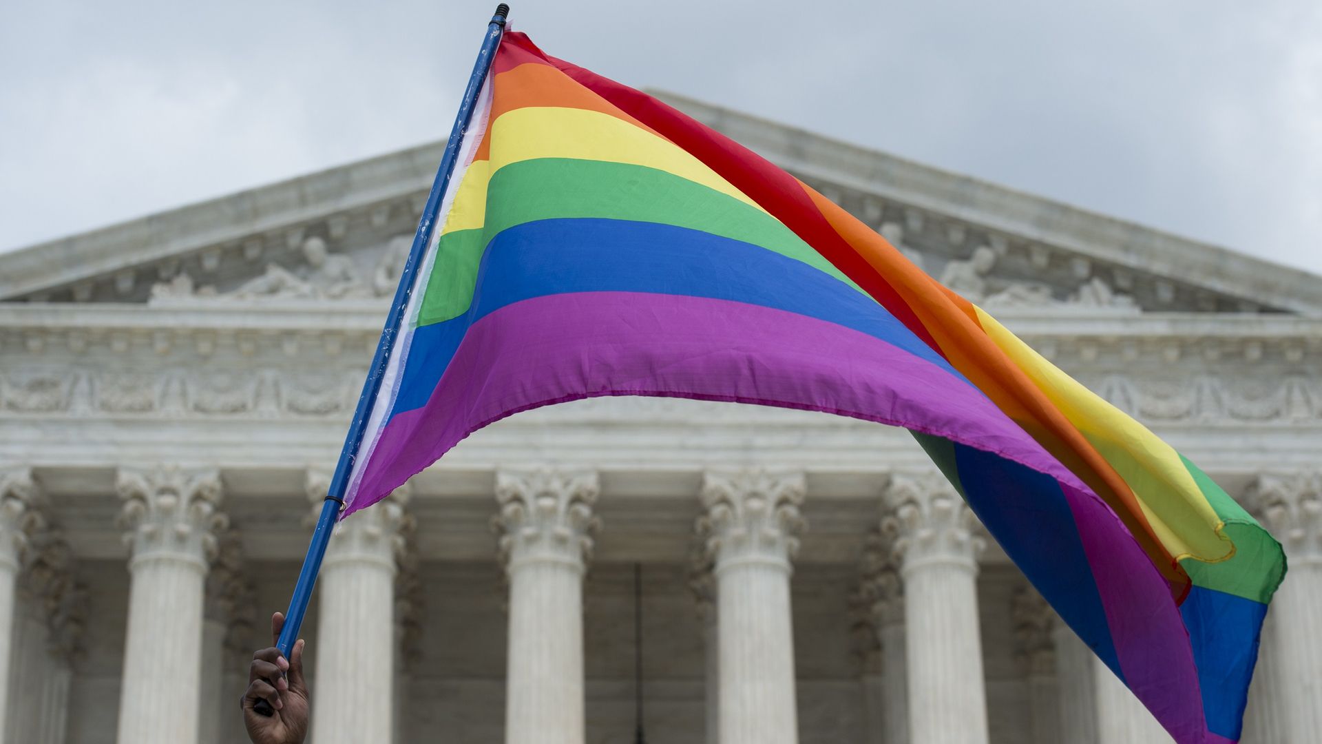 A rainbow flag flies in front of the U.S. Supreme Court.