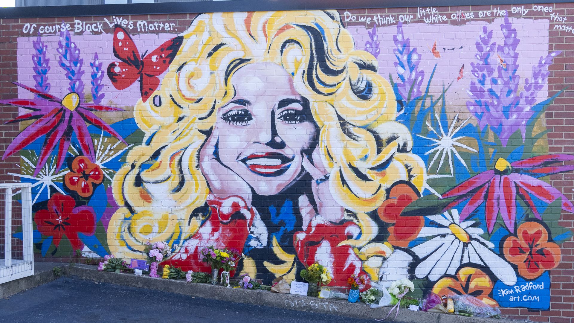 Flowers are laid beside a mural of country singer Dolly Parton on August 25, 2026 in Nashville, Tennessee. Parton passed away at the age of 80 on August 25, 2026.