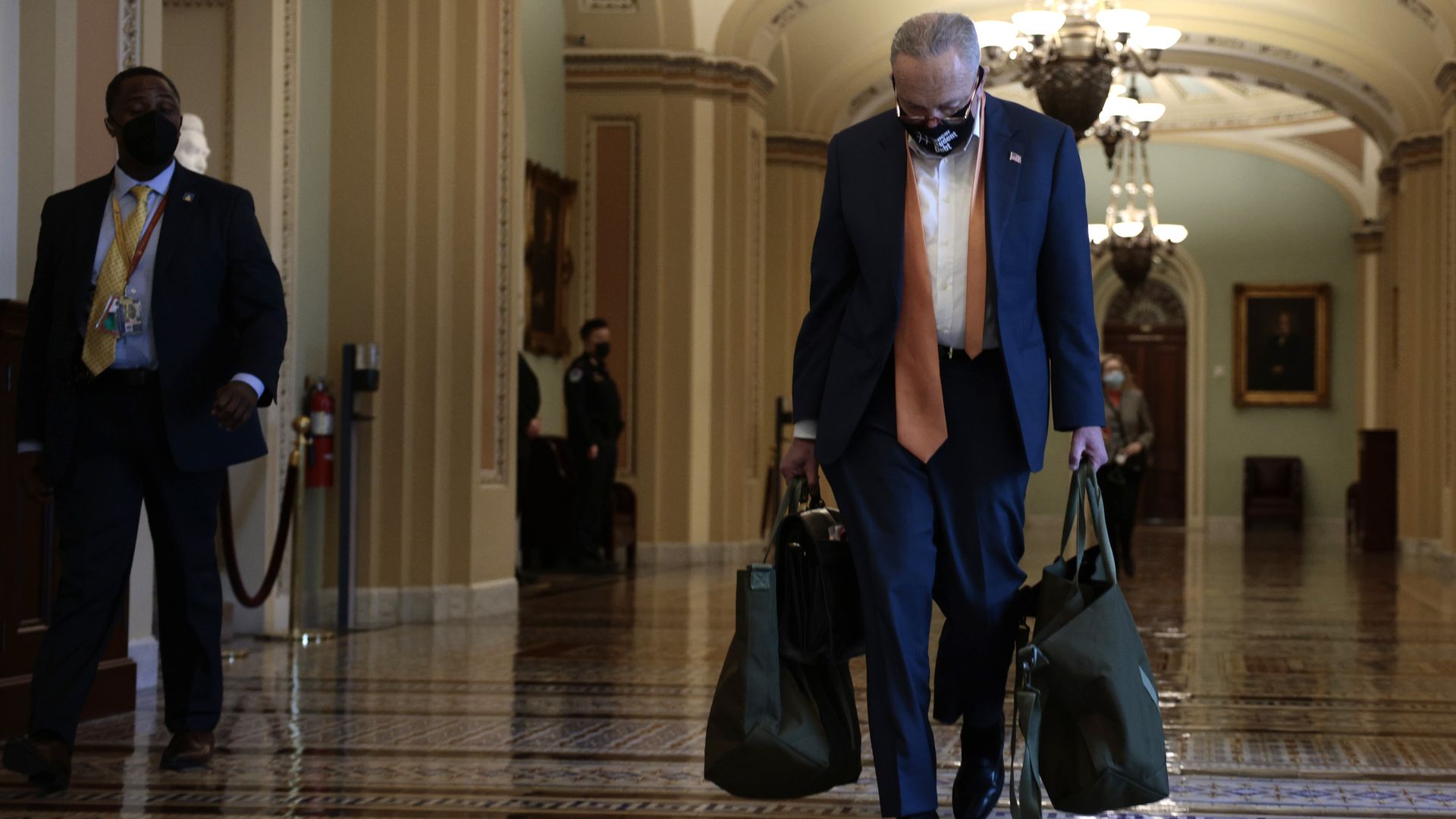 Senate Majority Leader Chuck Schumer is seen carrying his luggage as he returns to the Capitol on Monday.