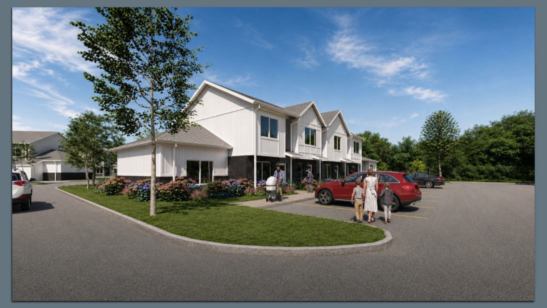 Row of white, two-story townhomes with peaked roofs and landscaped front yards, beside a parking lot with a red SUV; people, including a family with a stroller, outside under a bright blue sky.