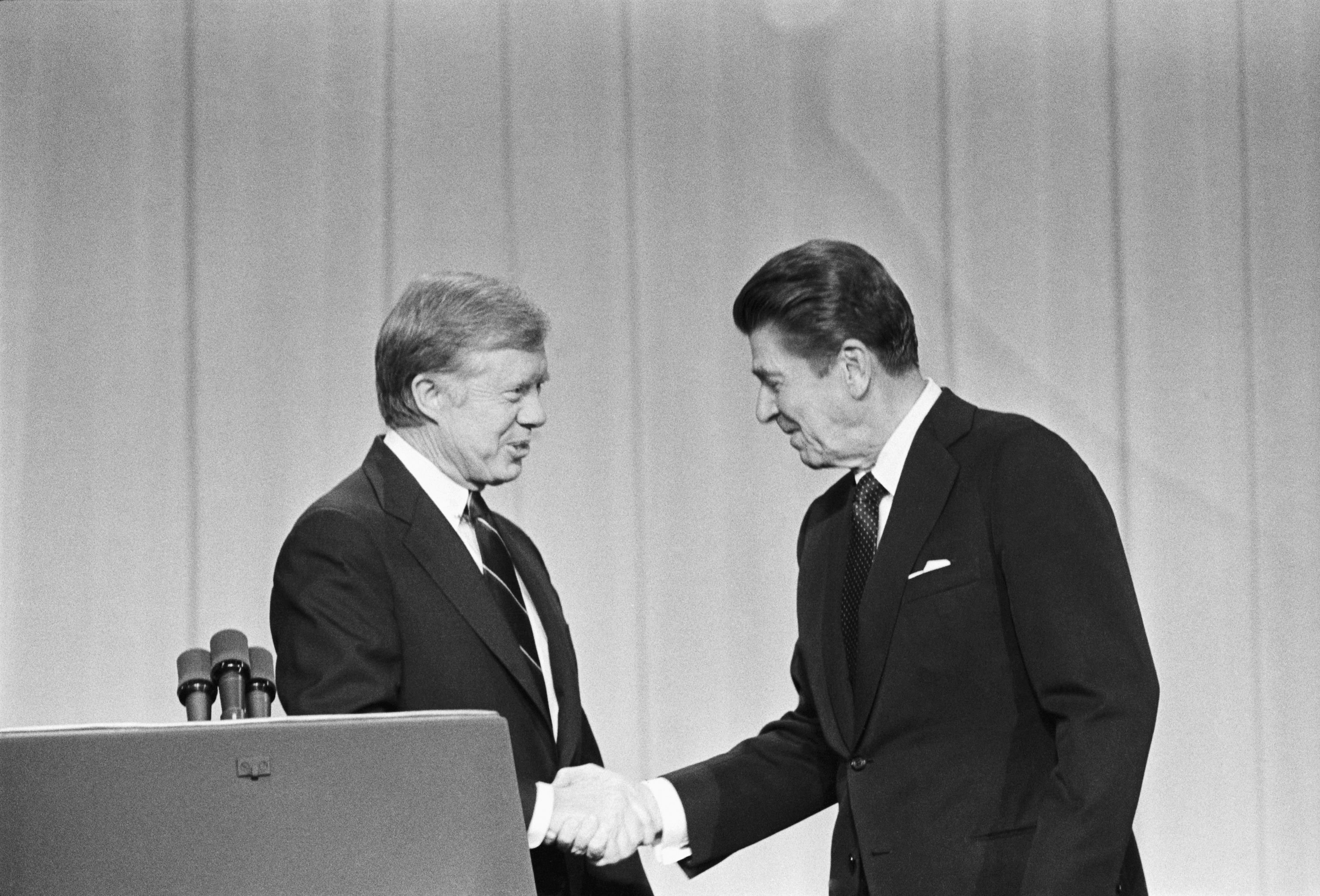 President Jimmy Carter and his Republican challenger, Ronald Reagan, shake hands as they greet one another before their debate on the stage of the Music Hall in Cleveland.