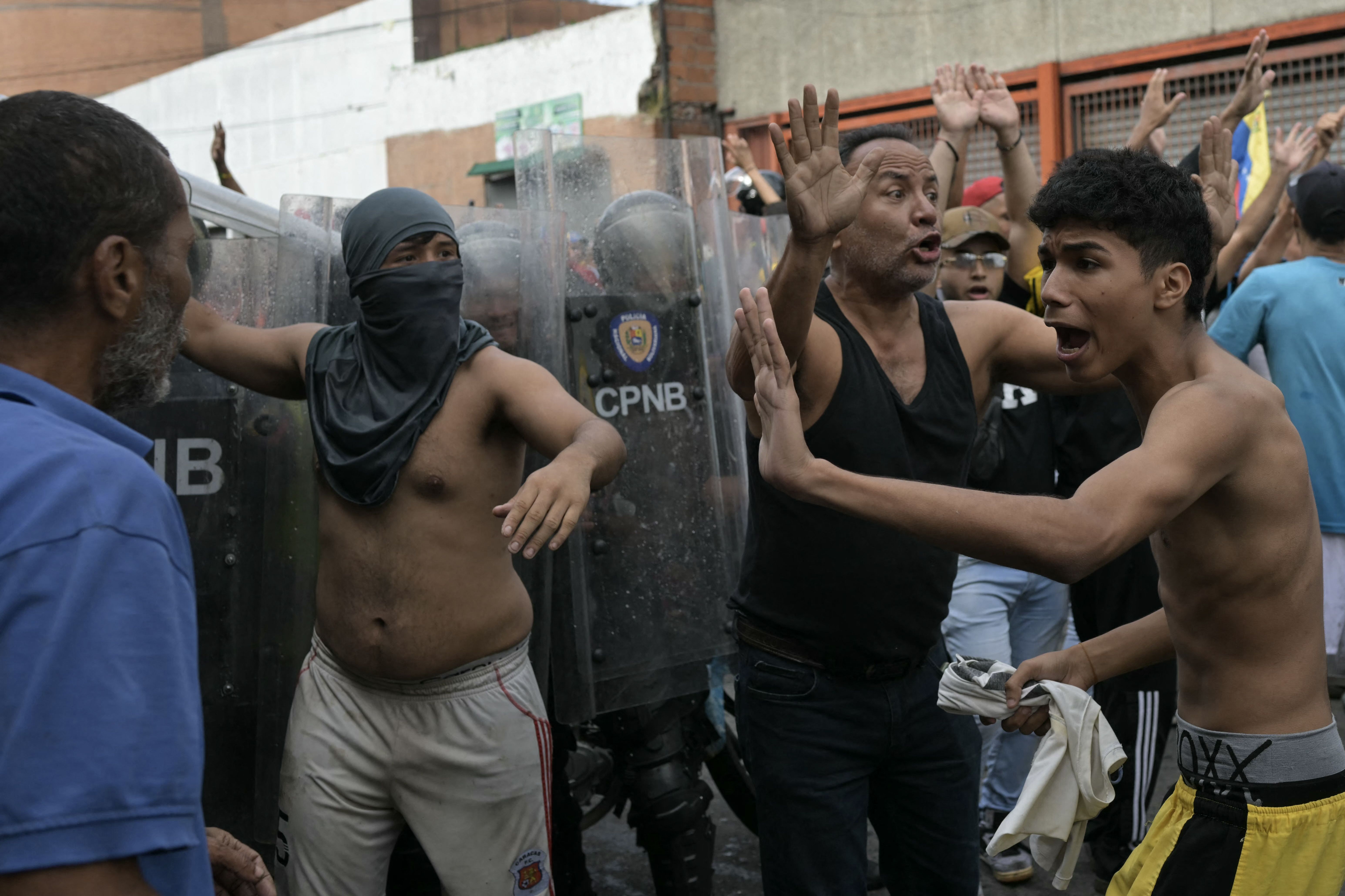 Demonstrators try to calm down among themselves as they clash with police officers during a protest against Venezuelan President Nicolas Maduro's government in Caracas on July 29, 2024, a day after the Venezuelan presidential election. 