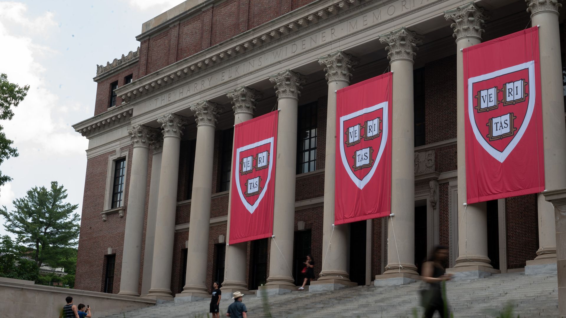 People walk past the Harry Elkins Widener Memorial Library on Harvard's campus on June 5, 2025.