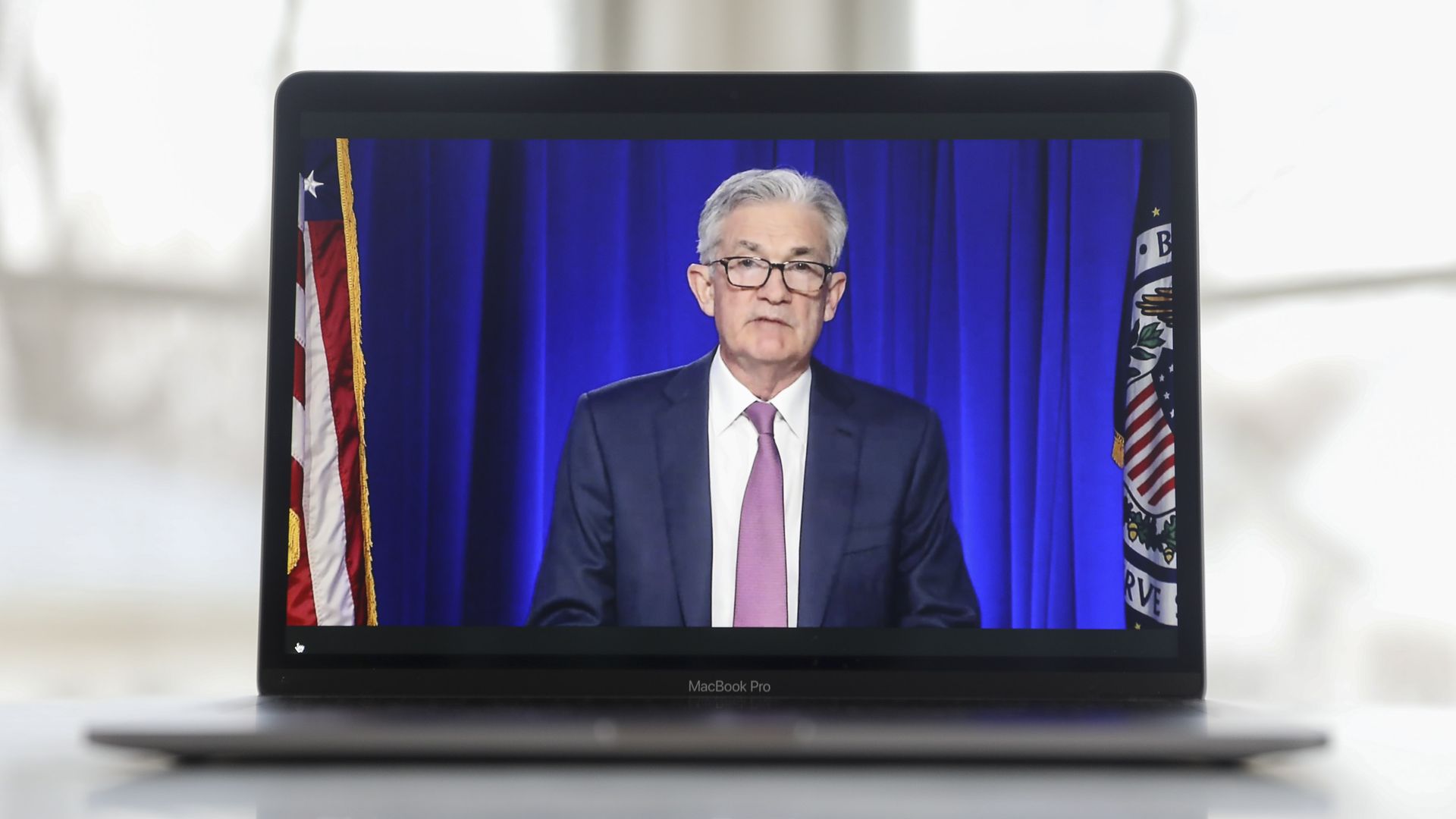 Federal Reserve Chairman Jerome Powell is seen on a laptop screen during a virtual news conference.