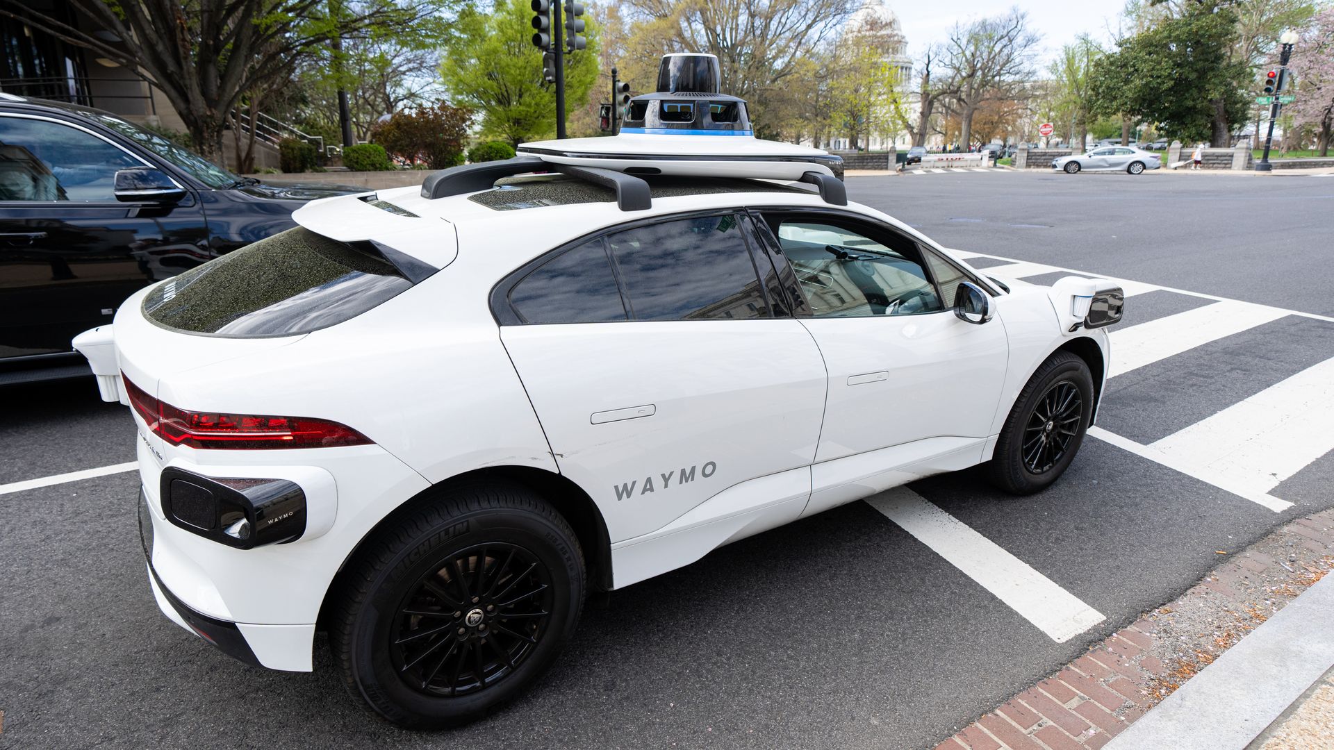 A Waymo autonomous vehicle with a driver on D.C. streets