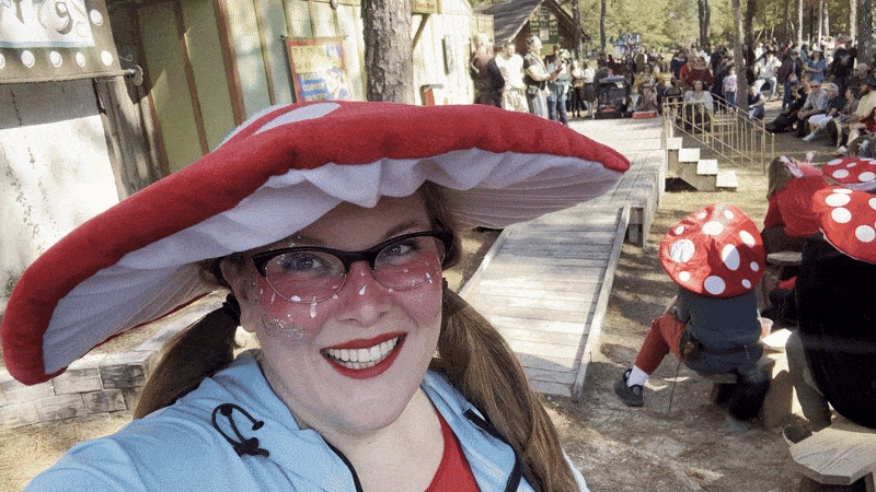 Video shows Carlie wearing a red and white mushroom hat and panning to a shot of the crowd at the Louisiana Renaissance Festival.