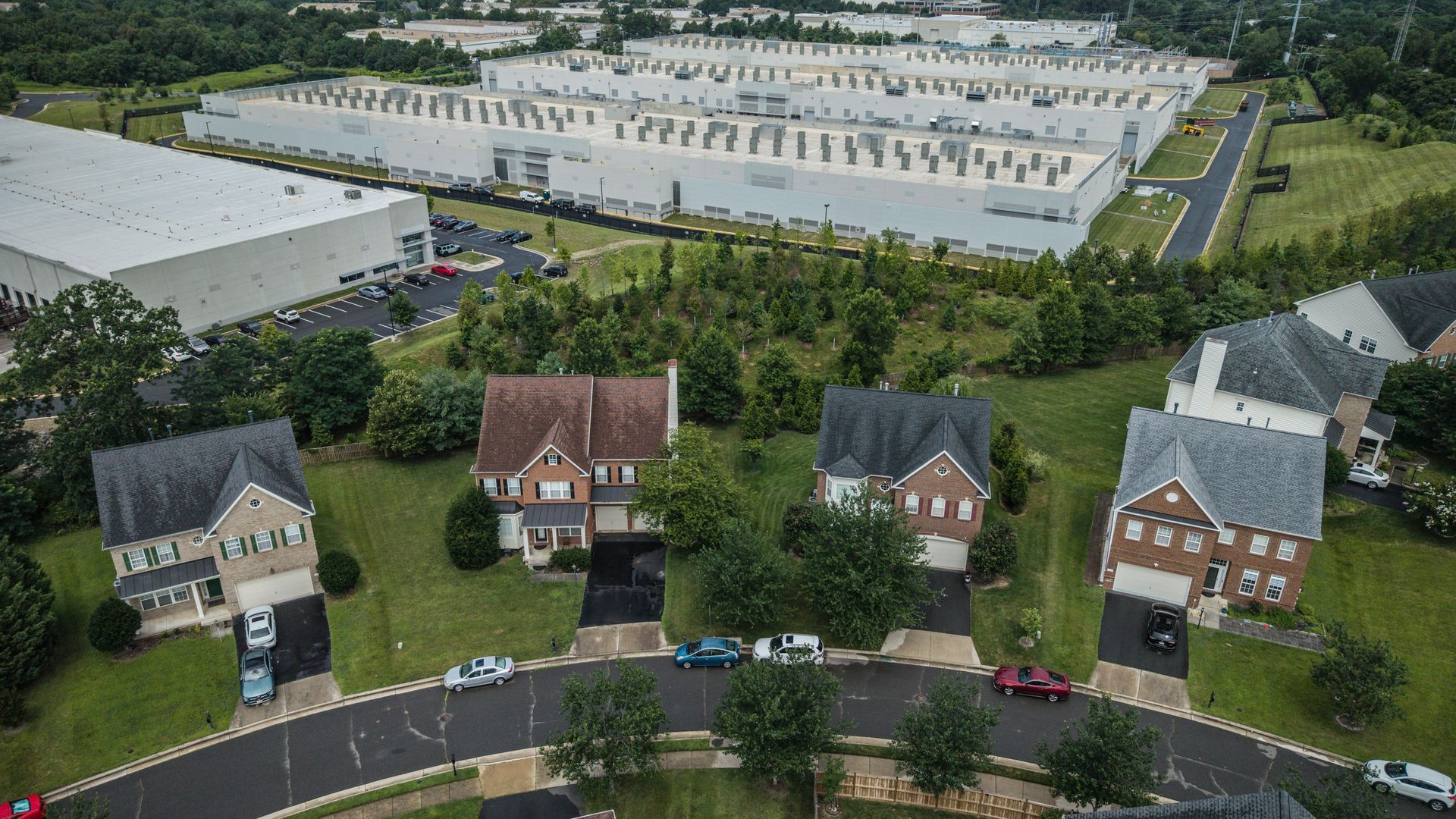 A strip of homes with a data center behind them.