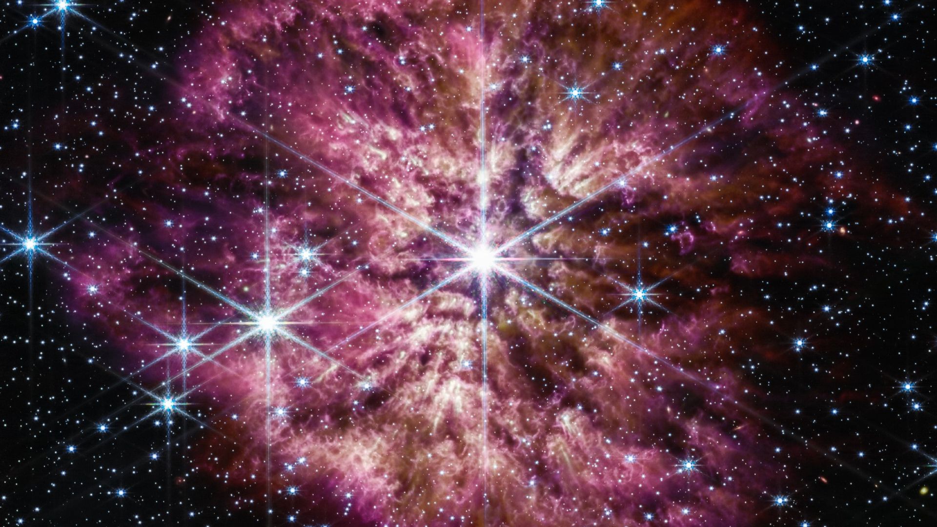 A star surrounded by gas glowing in red and pink