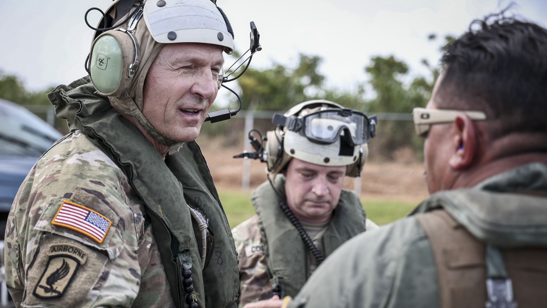 Gen. Randy George greets another man while clad in flight gear.
