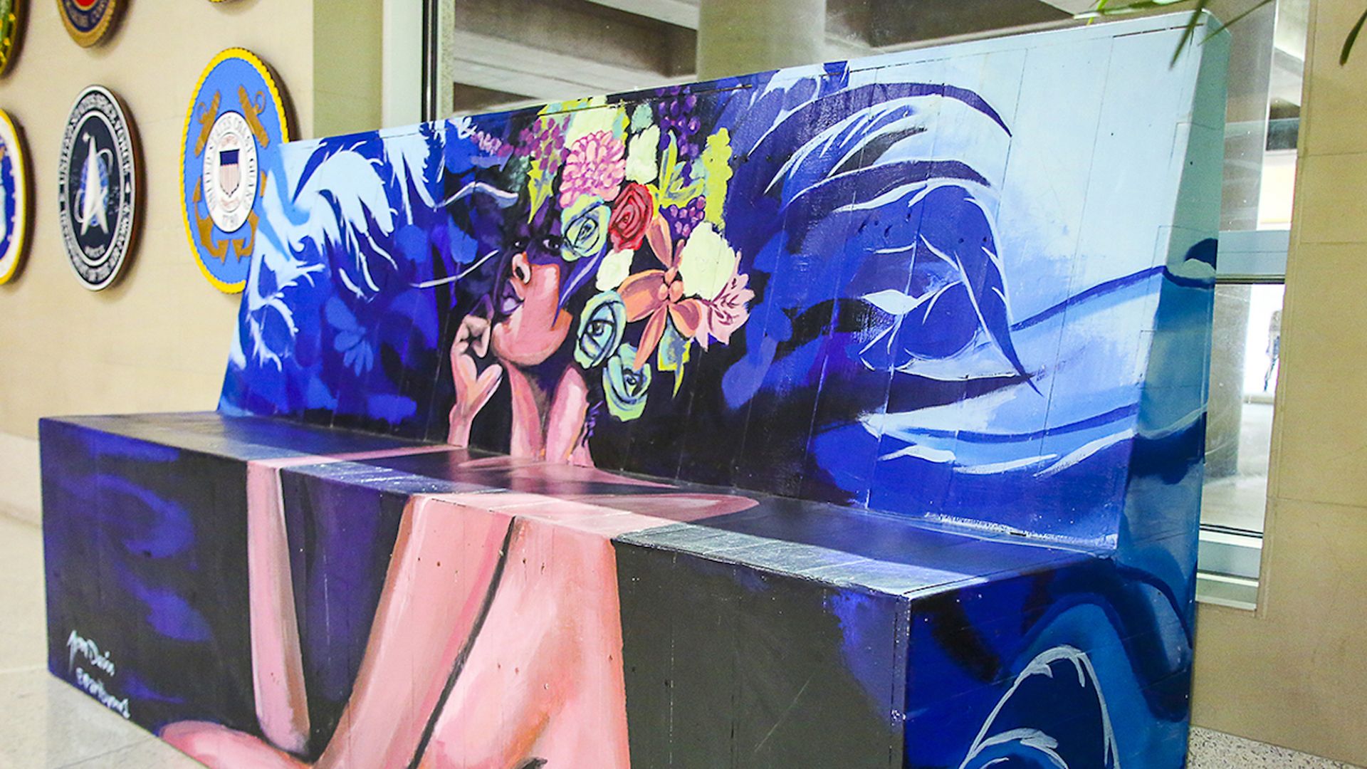 Photo of a decorated bench with a woman wearing a flower crown in the center. 