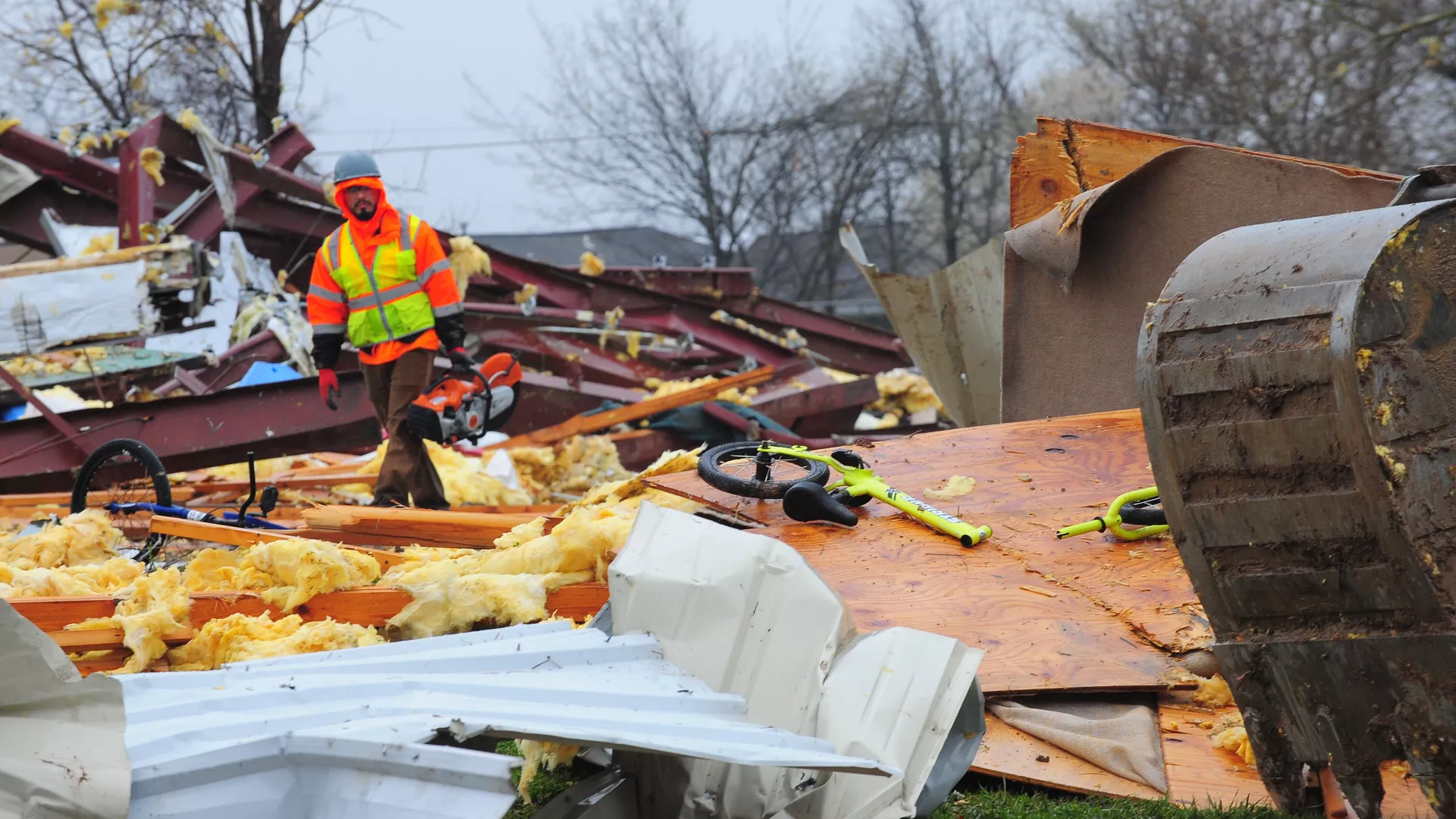 A worker looks at damage from the tornado