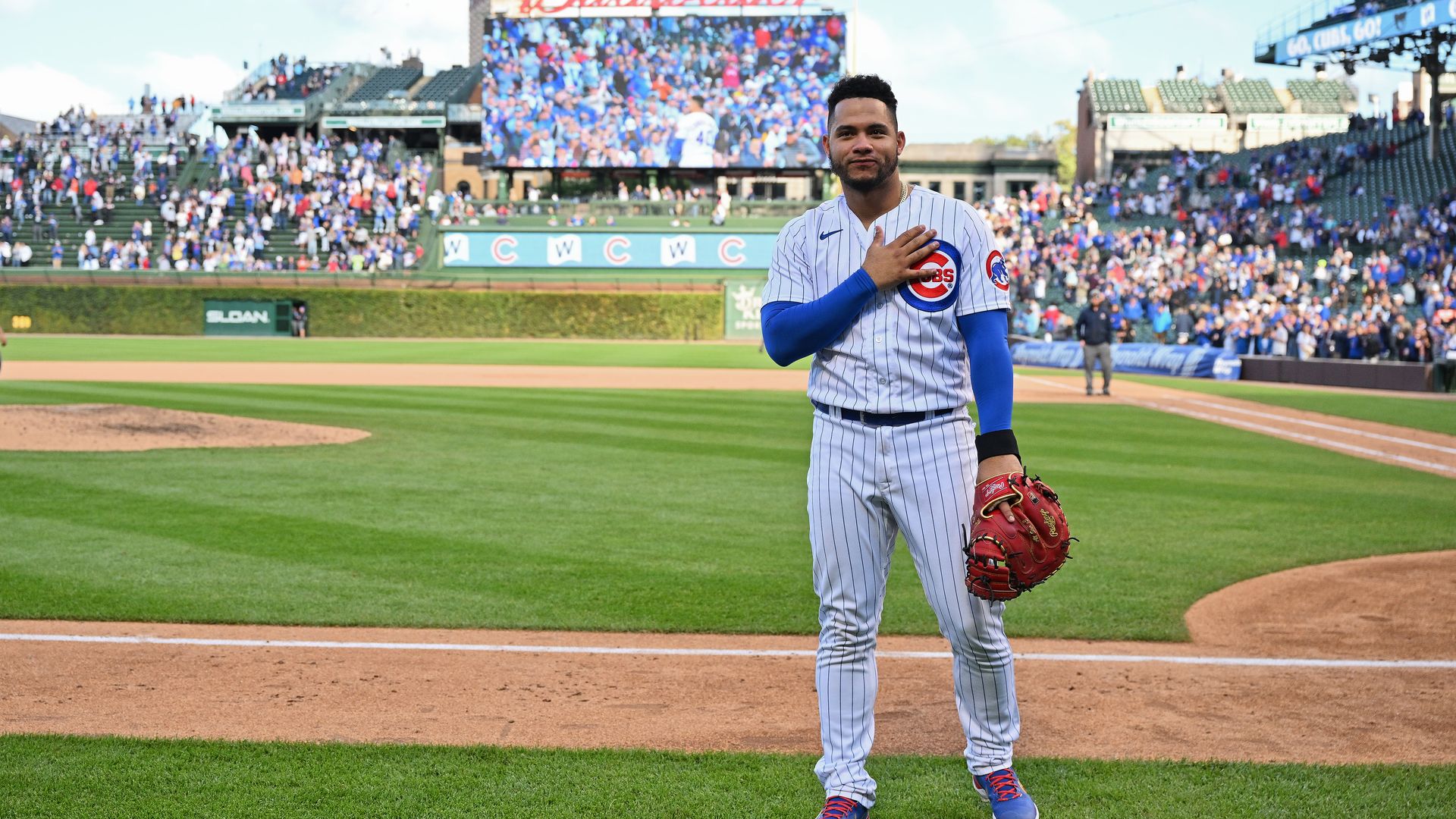 Photo of a baseball player holding a glove. 