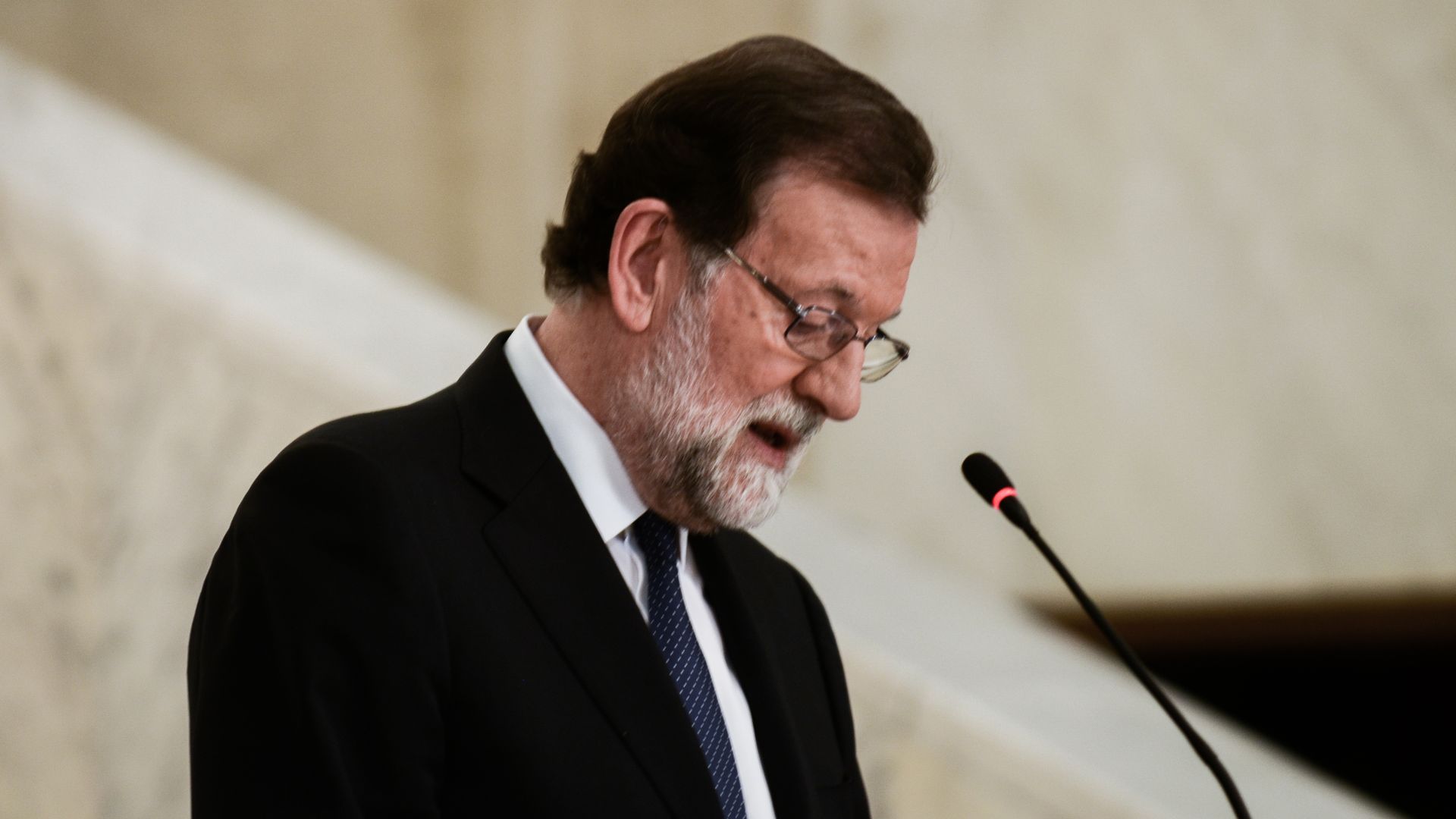 Spanish PM Mariano Rajoy looks down while speaking at a press conference
