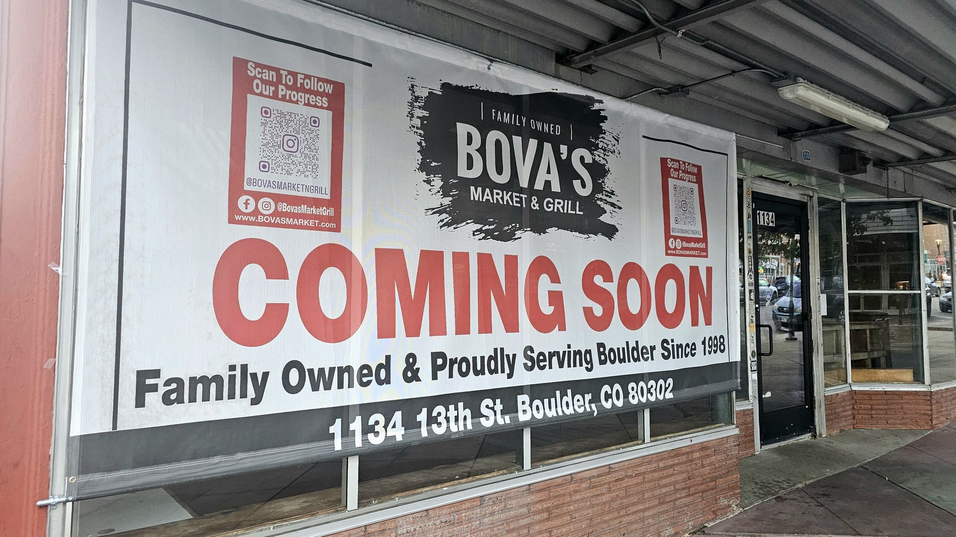 Storefront window with a large white banner reading "COMING SOON" in bold red letters, flanked by red QR-code posters. A black brush-stroke sign says "BOVA'S MARKET & GRILL"; glass door and street scene in the background.