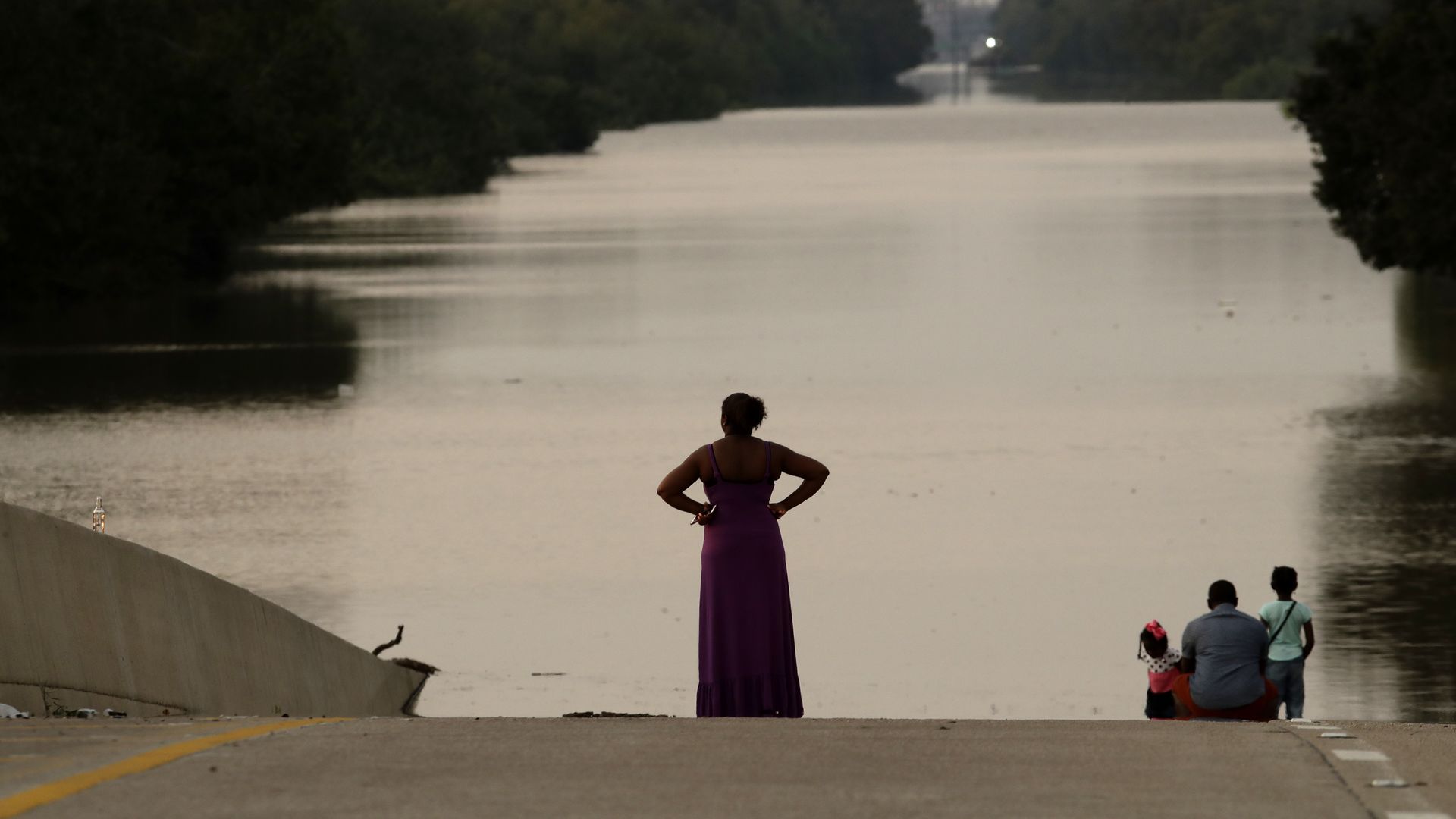 Woman and family look out at floodwaters in Houston, Texas. 