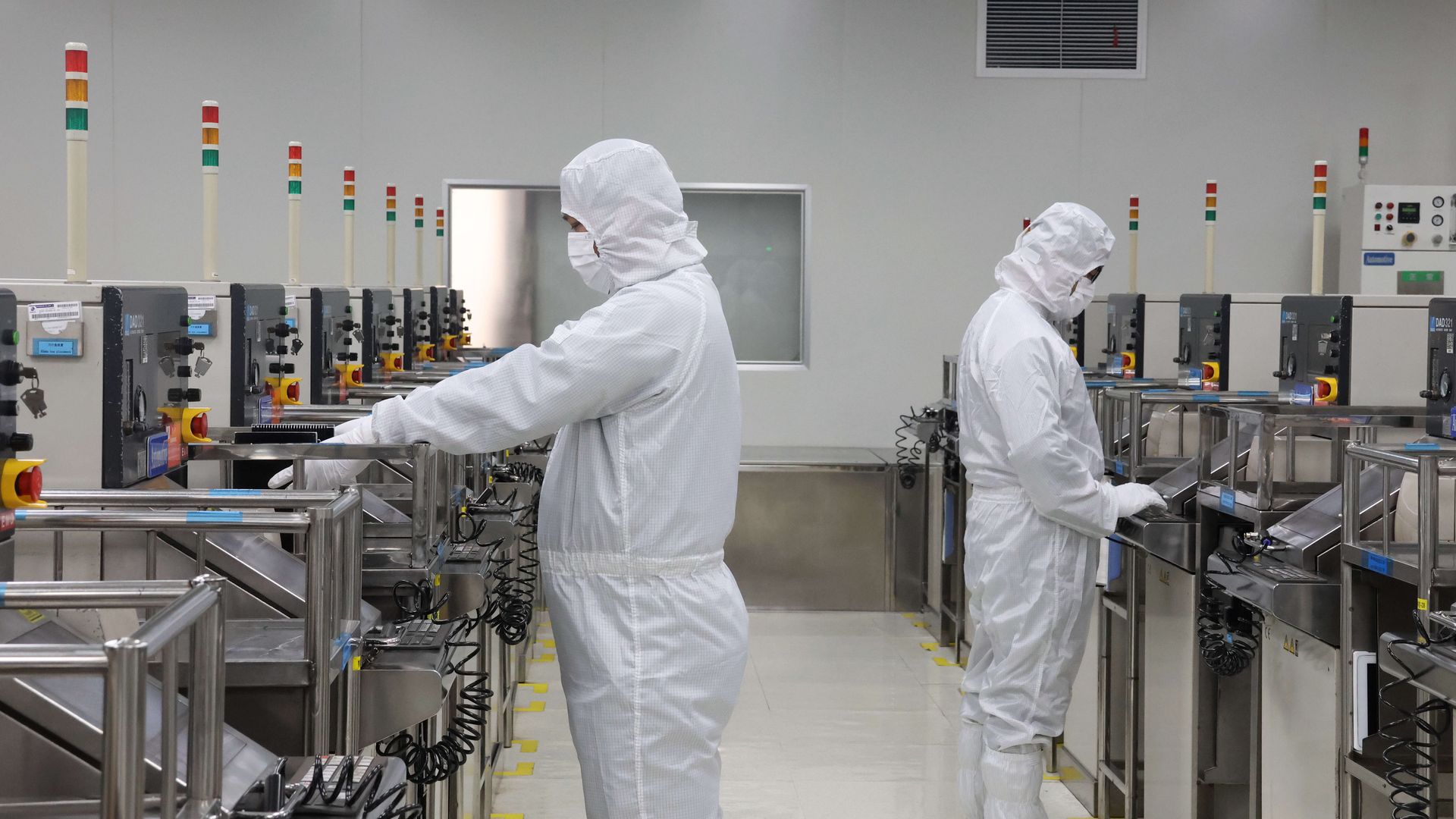 Workers in protective gear at a factory making automobile semiconductors in China.