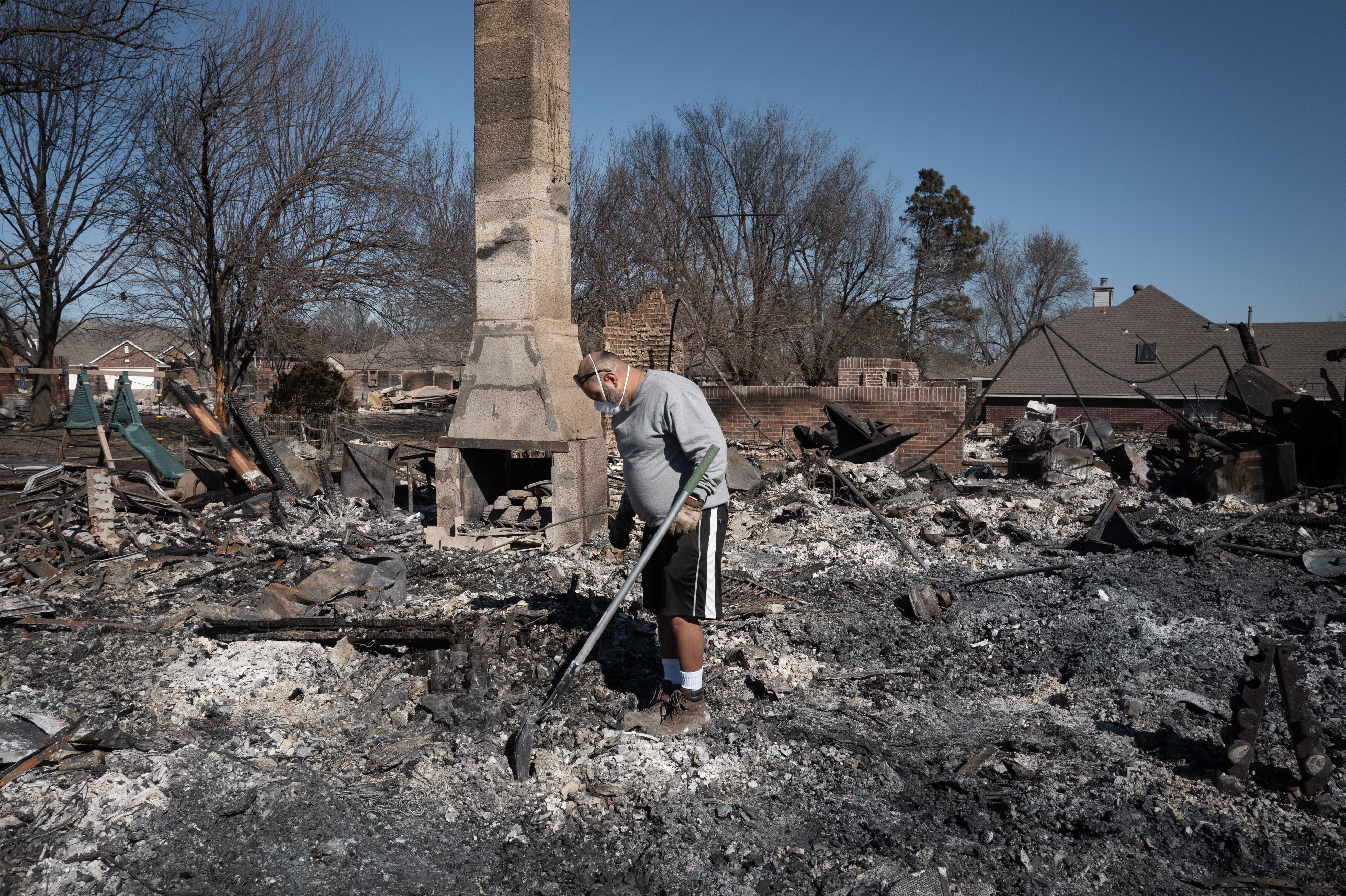 Jake Cuellar searches for salvageable items after his home was destroyed during Friday's wildfires on March 16, 2025 in Stillwater, Oklahoma. 