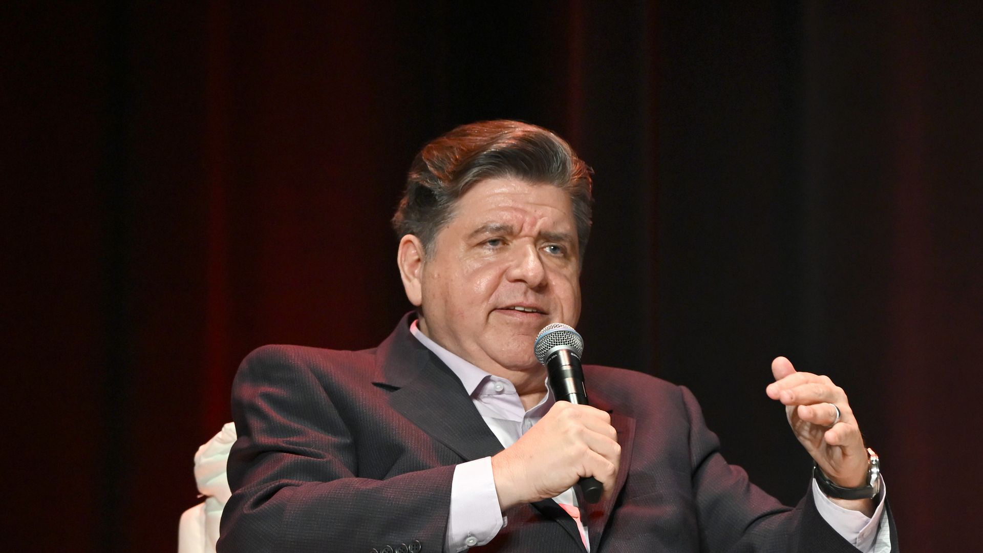 JB Pritzker speaks into a microphone.