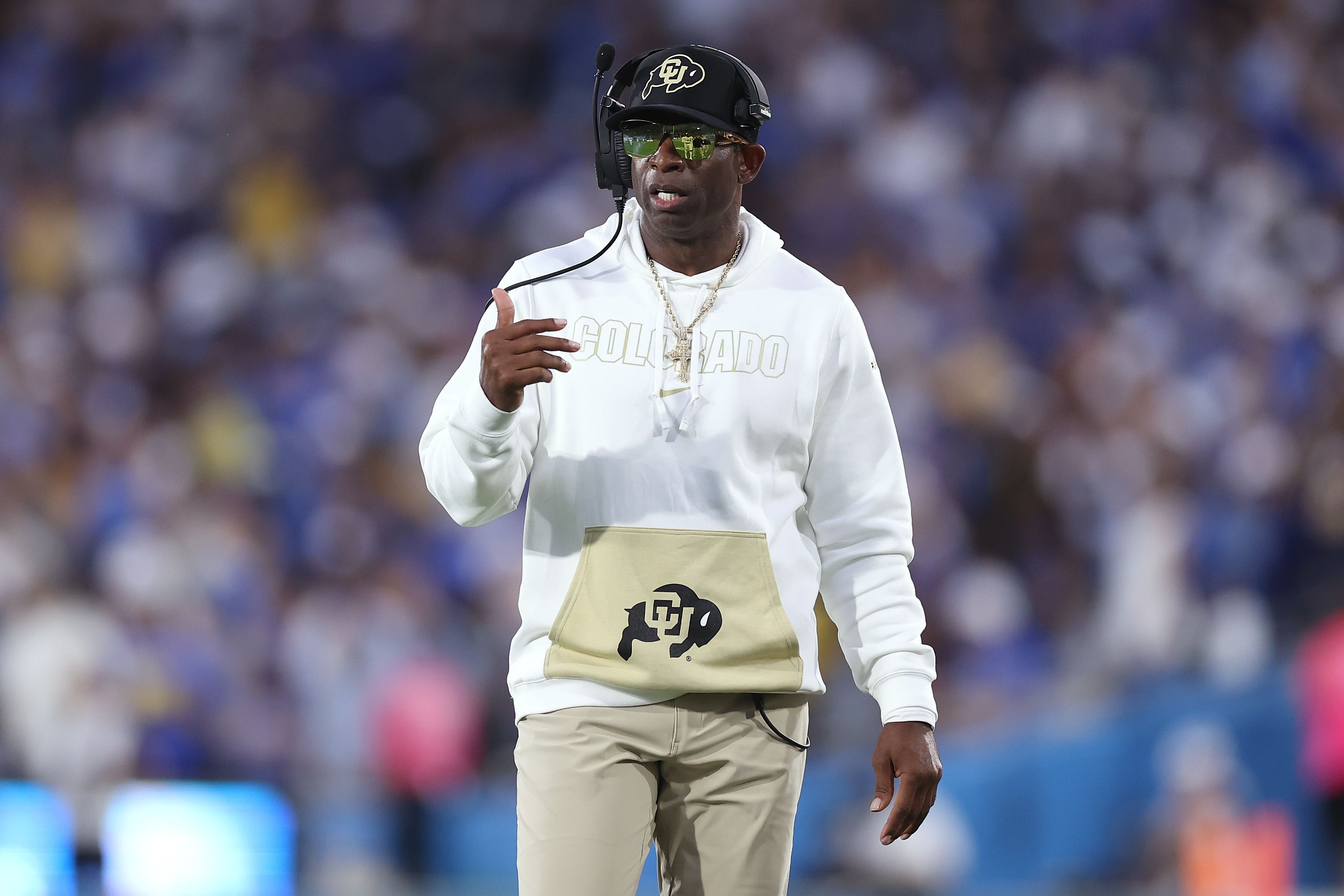 A black man in a white hoodie with a CU Buff