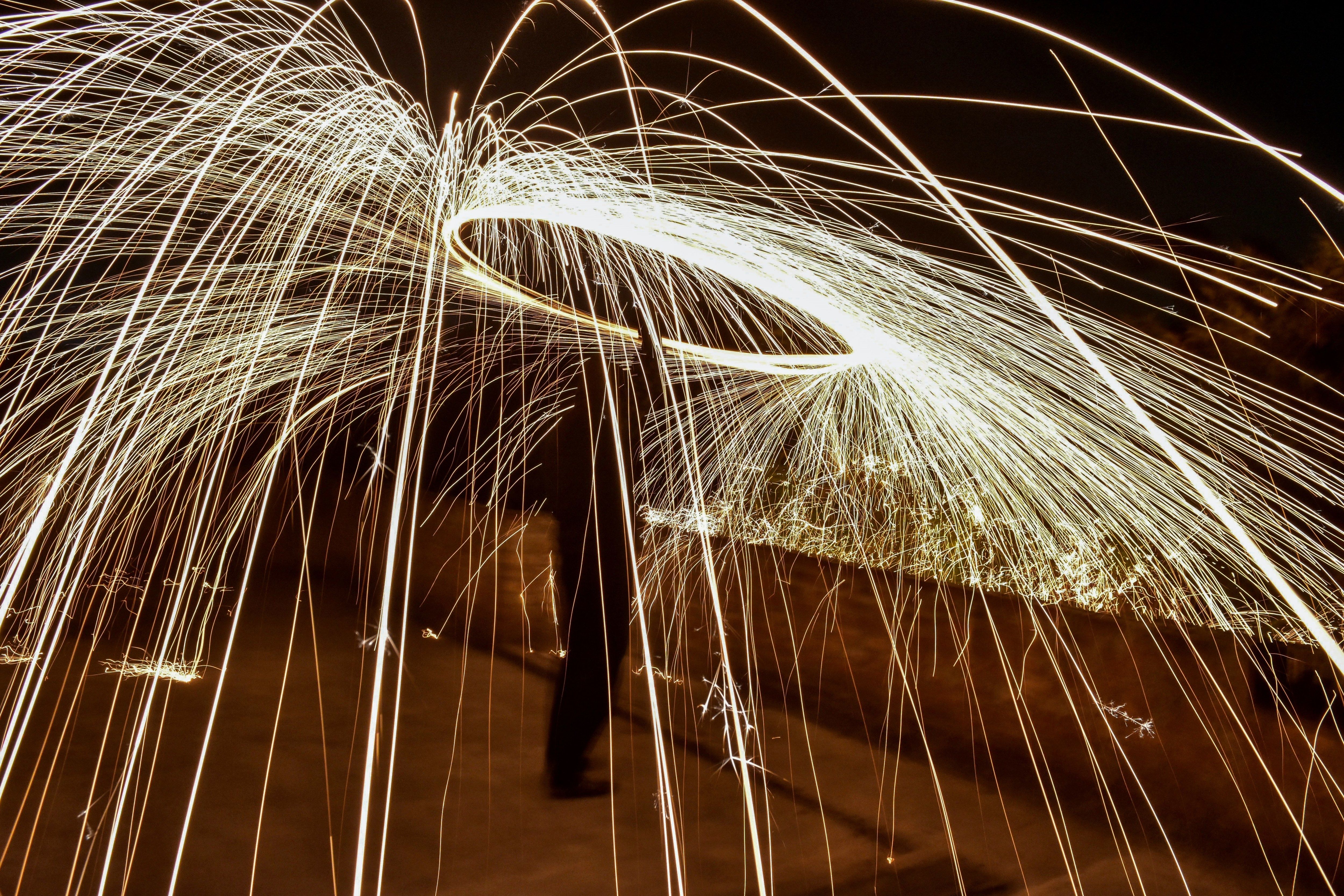  A boy spins a burning steel wool with a sling performing light painting during the New Year celebrations in Rajpura town